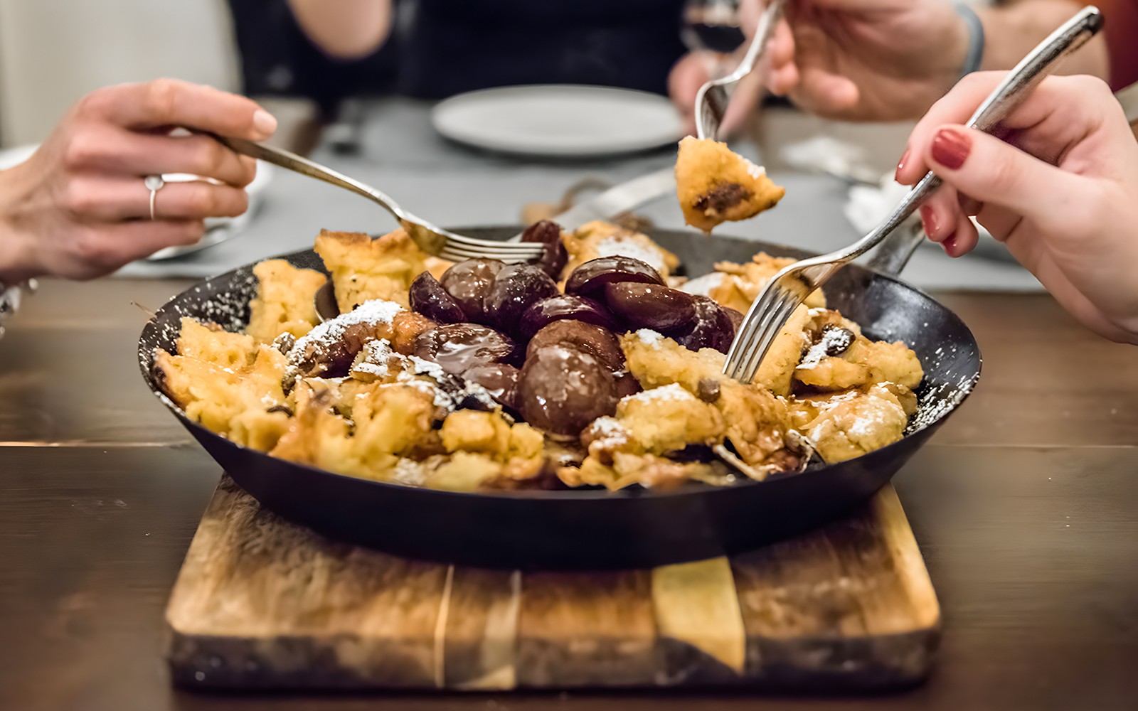 Kaiserschmarrn cooking class with participants tasting the dish in Vienna.