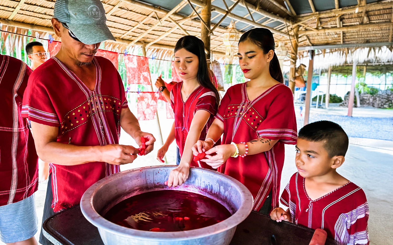 Orang ramai dalam pakaian tradisional menyertai aktiviti mewarna di Keluarga Gajah Kerchor, Phuket.