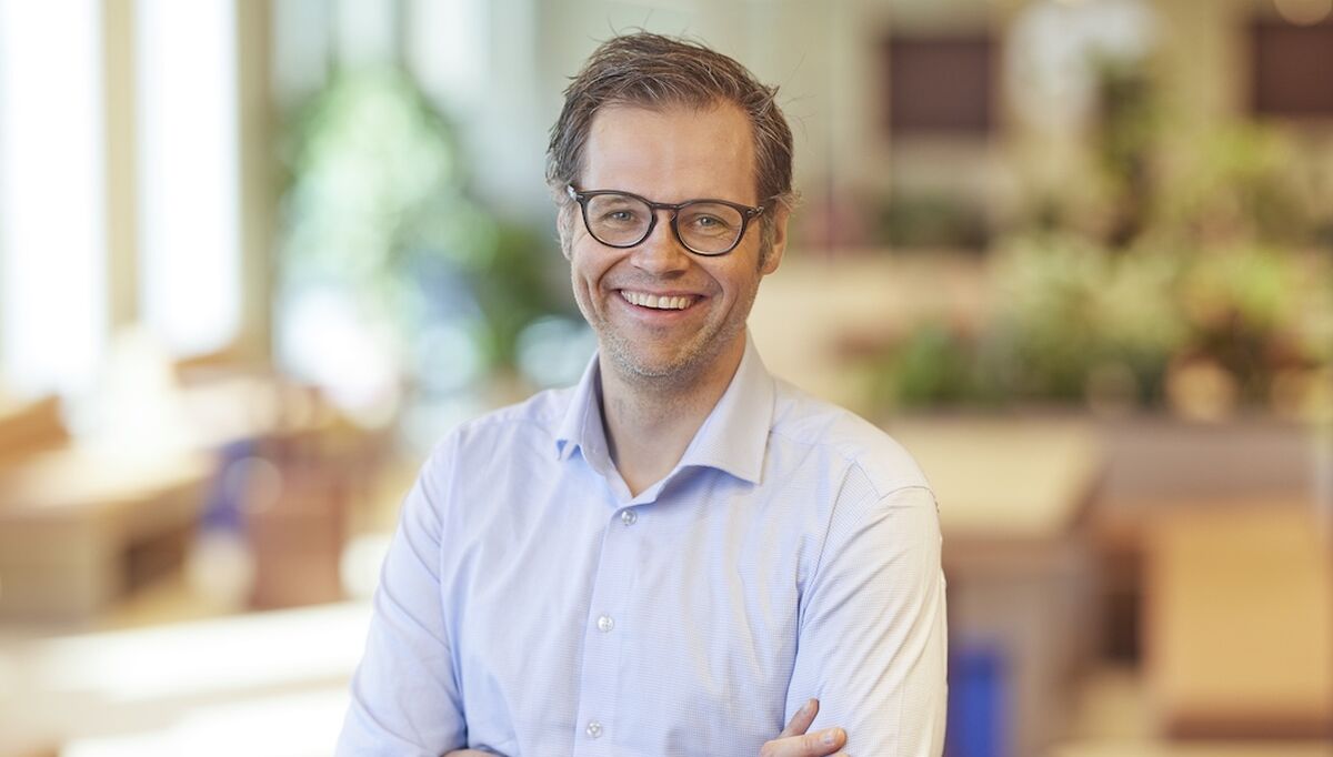 Adm. dir. VVS Norge Kristian Reistadbakken smilende i blå skjorte foran fargerik bakgrunn i Brynsengfaret 6