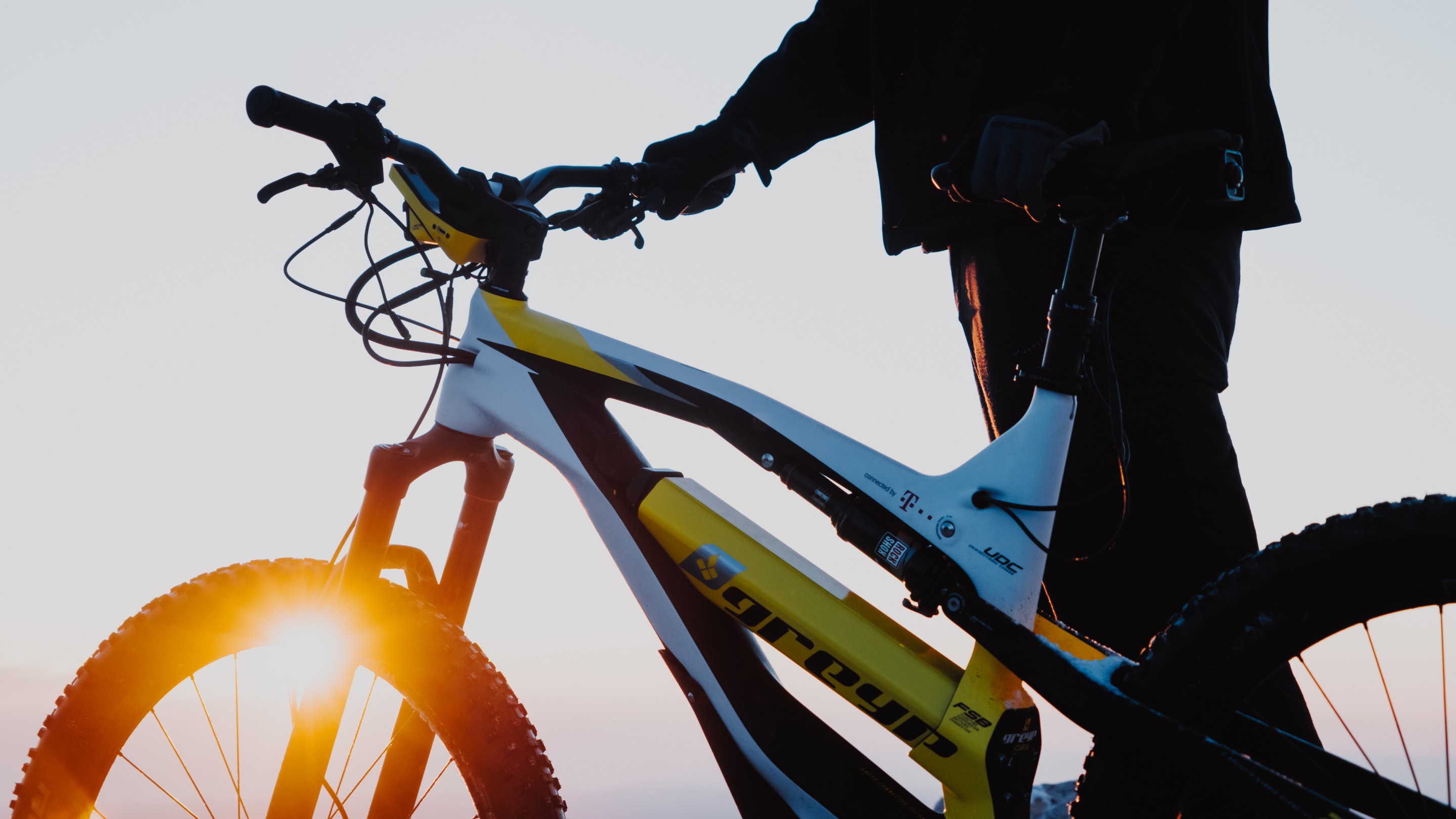 White, yellow and black Grepy emtb being held during sunset.