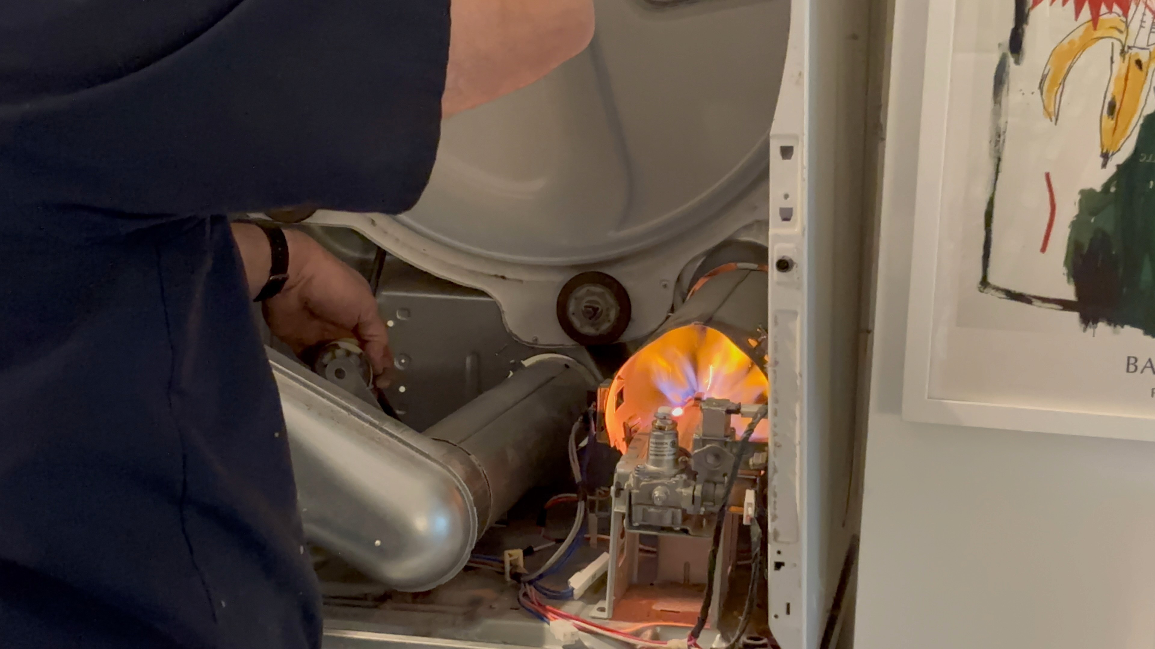 A man fixing a refrigirator on his knee in a traditional american kitchen
