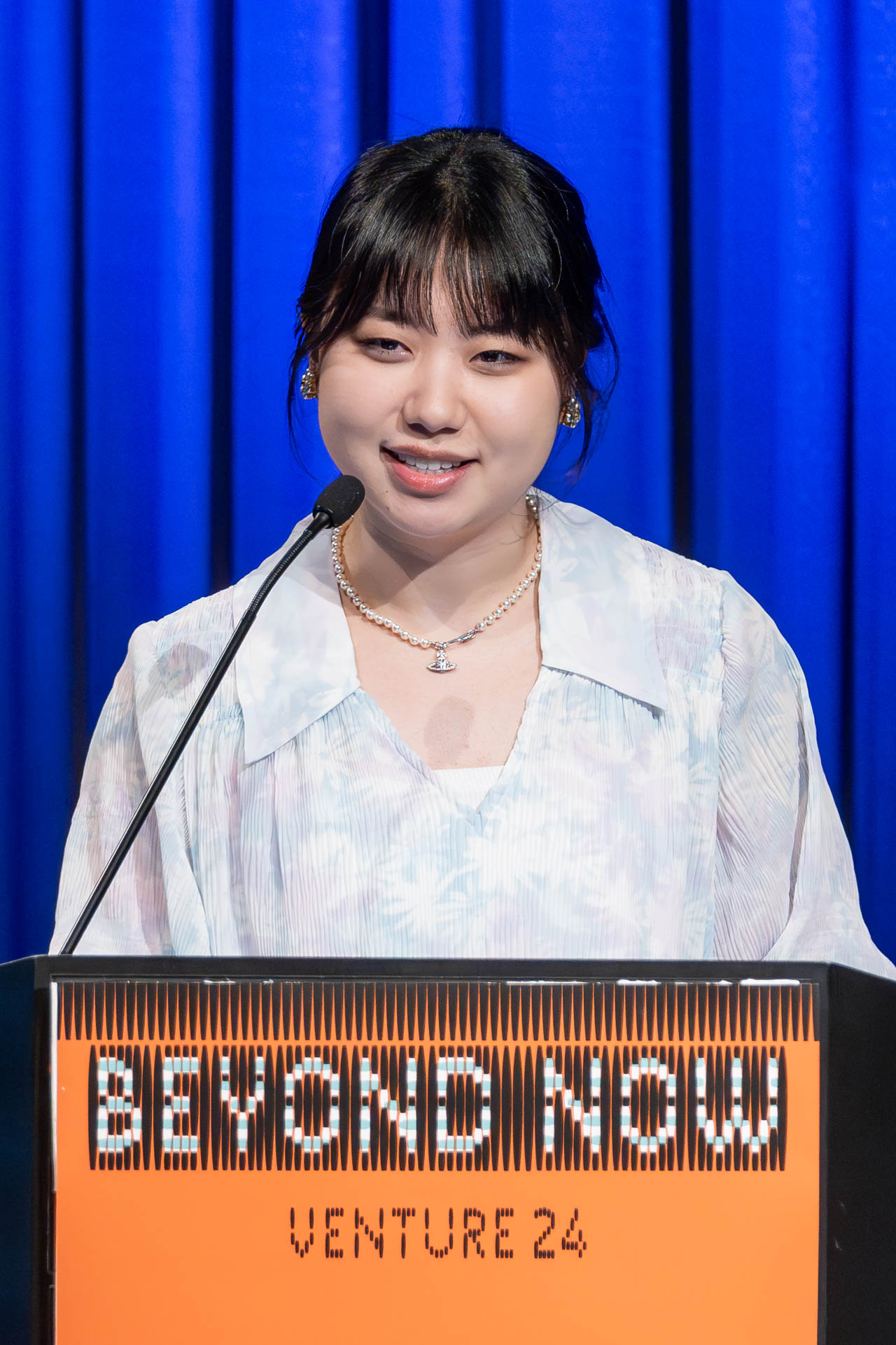a student at a podium presenting a project in a Theatre