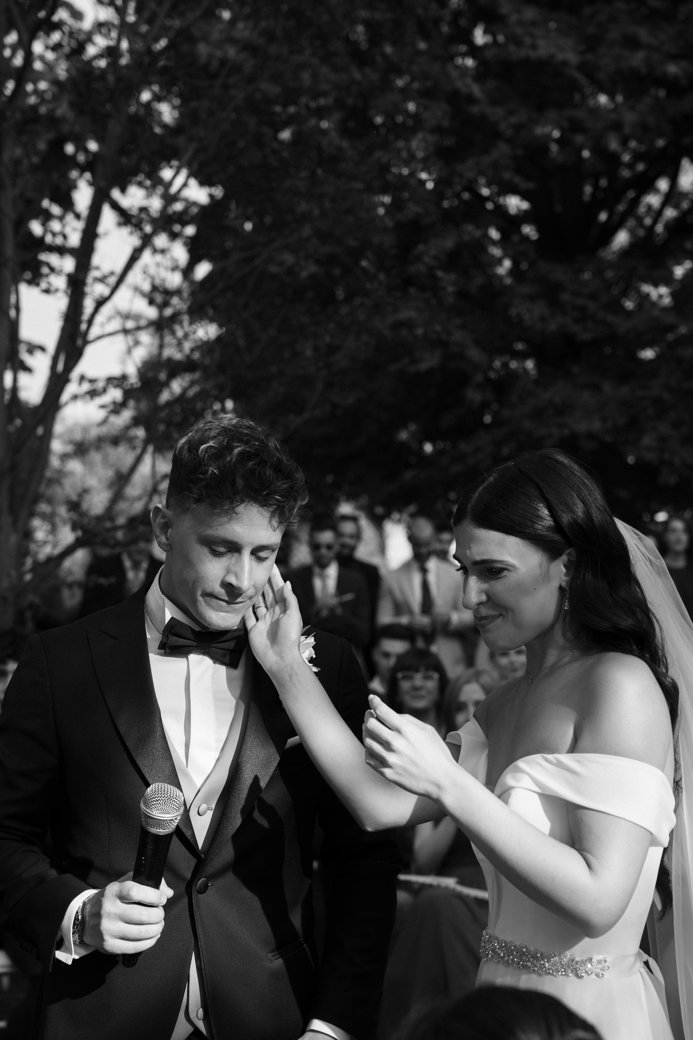 Sposa tocca il viso dello sposo sorridendo nel giardino di Villa Negri, momento di tenerezza durante il matrimonio