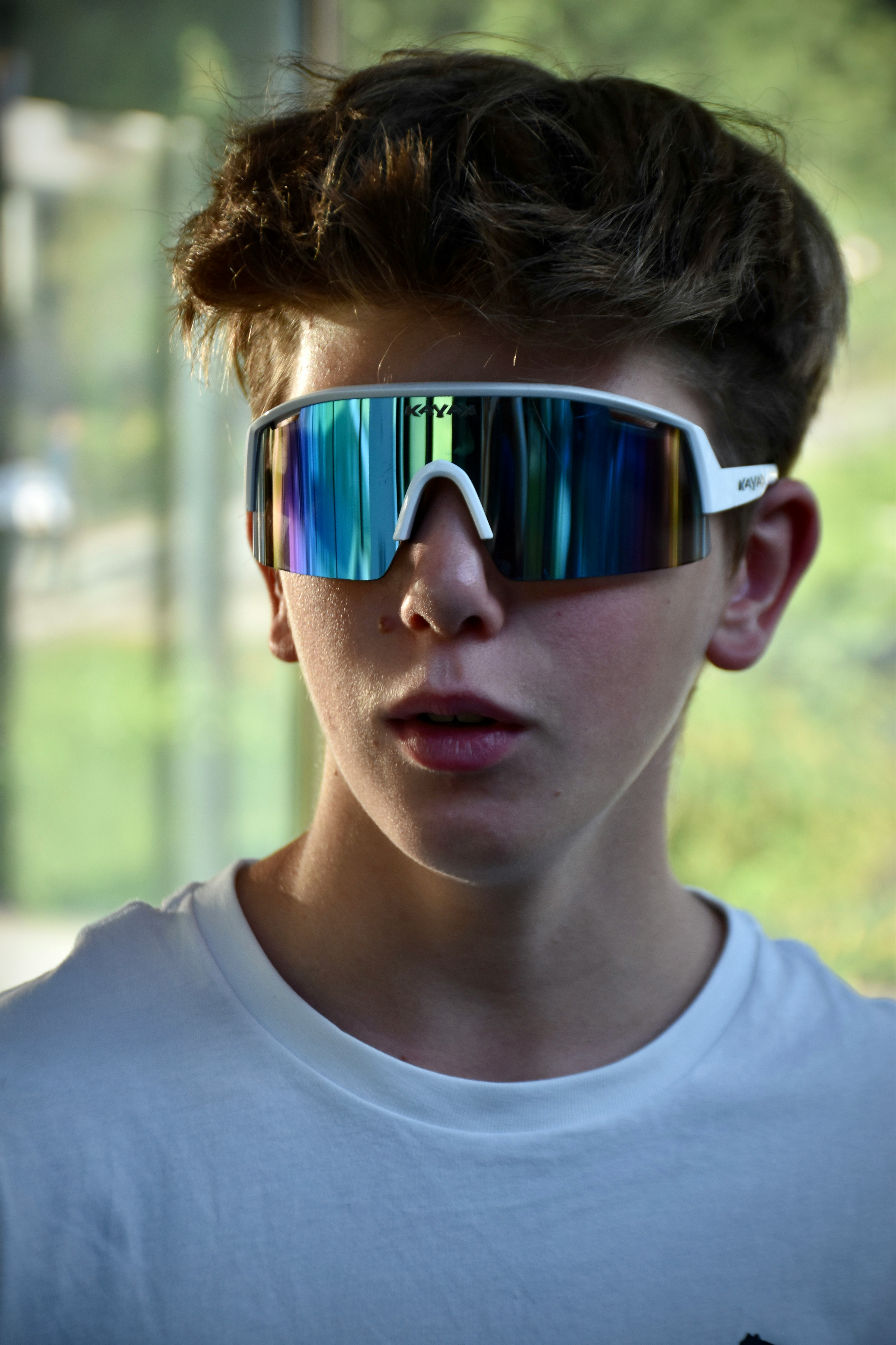 a young boy wearing a pair of mirrored sunglasses