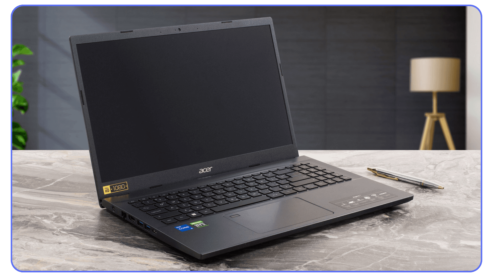 An Acer laptop with a 1080p screen sitting on a desk with a pen next to it and a lamp in the background.