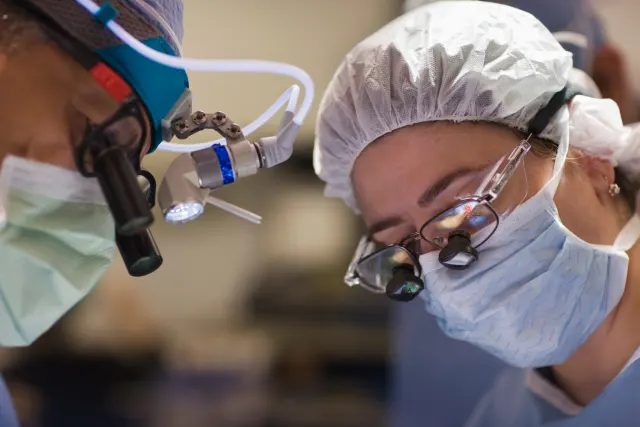Equipo médico con lupas de precisión durante una intervención quirúrgica cubierta por el seguro de salud Allianz en Murcia