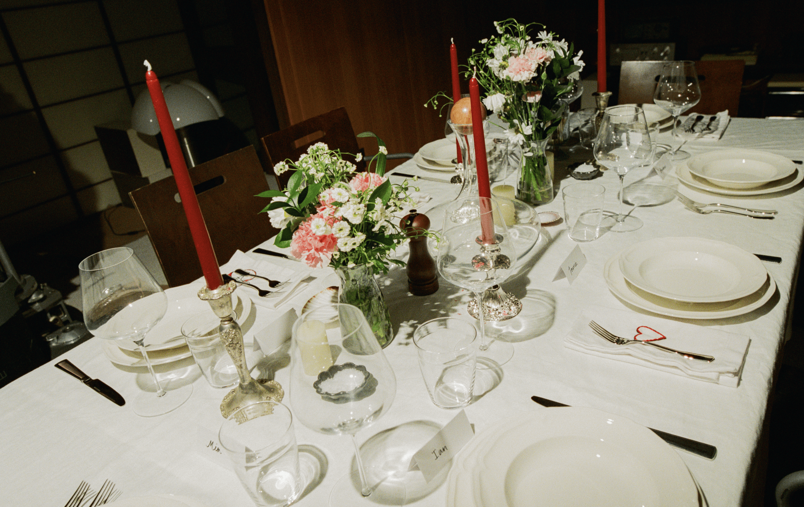 A decorative floral arrangement spills over a table draped in red fabric, creating an elegant atmosphere.