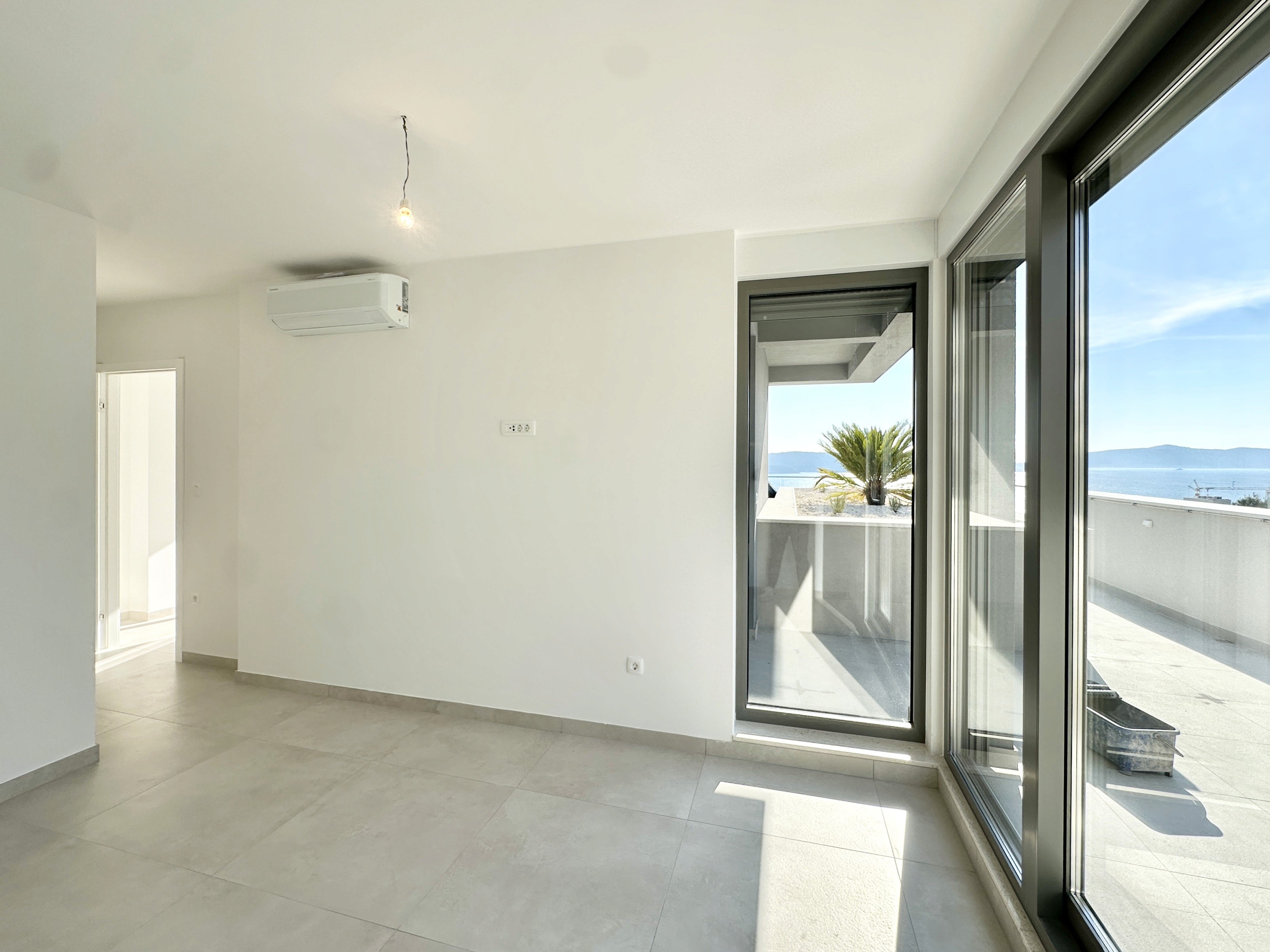 Black sports car in front of a modern, futuristic curved building.