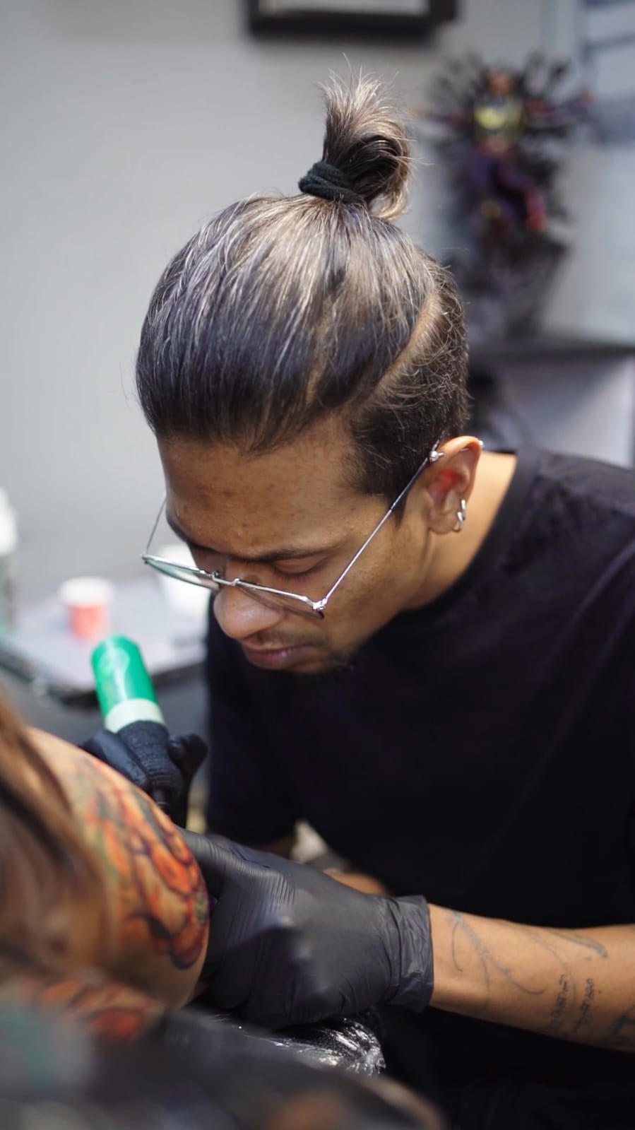 A woman with shoulder-length brown hair and freckles smiles softly. She wears a beige blazer over a white shirt in a warmly lit room, conveying professionalism and warmth.
