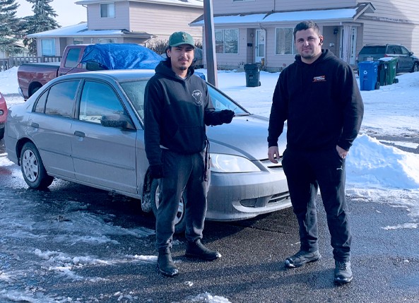 CarKeyAction automotive locksmiths standing beside a customer’s vehicle during a service call in Calgary