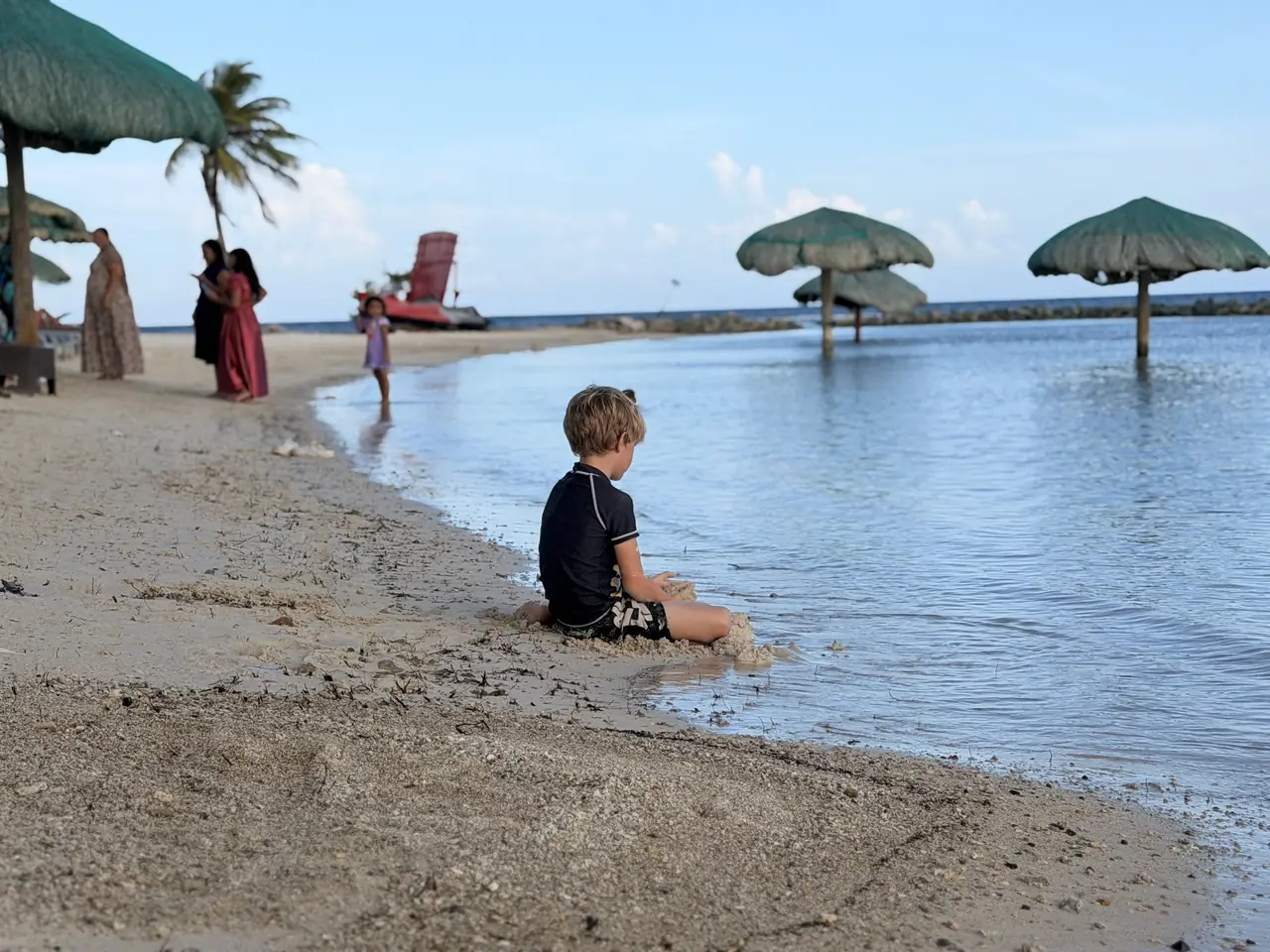 Thatched umbrellas and calm, netted water at Las Palmas.