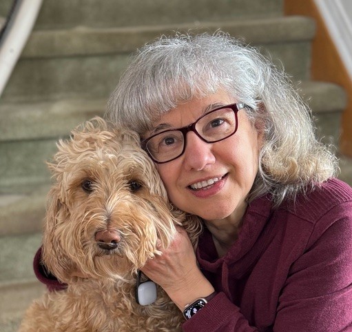 A client's mother, angela, is pictured smiling next to her golden doodle dog