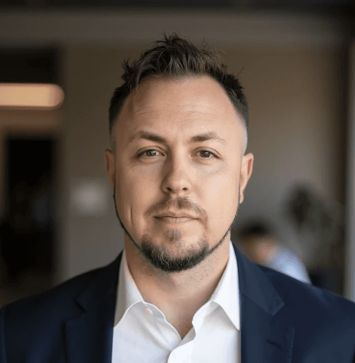 a man in a suit and tie sitting in a chair