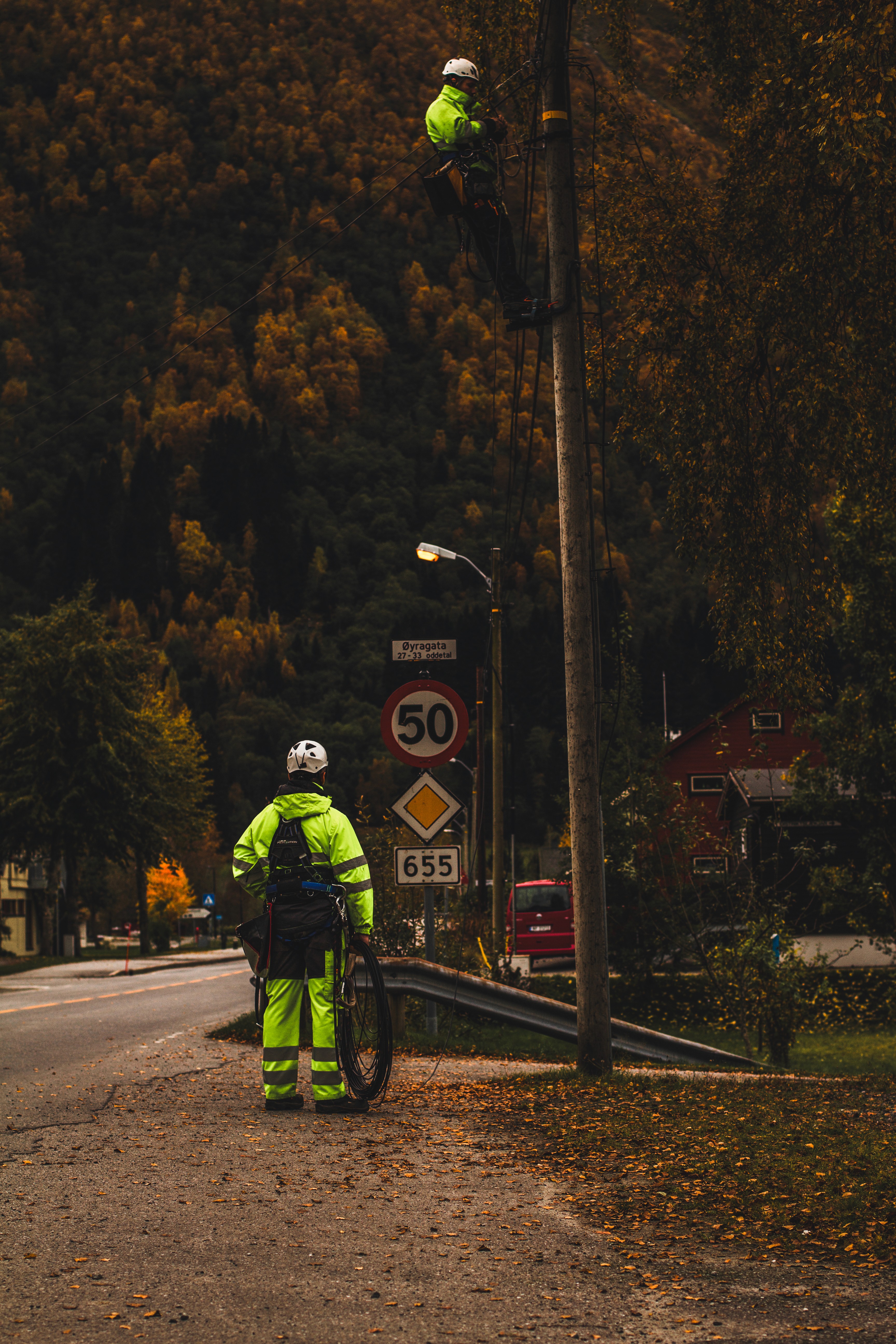 Fibertekniker som klatrer i stolpe