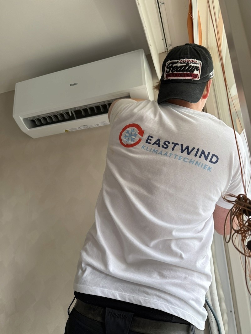 Jeffrey van Eastwind Klimaattechniek installeert een airco aan de muur