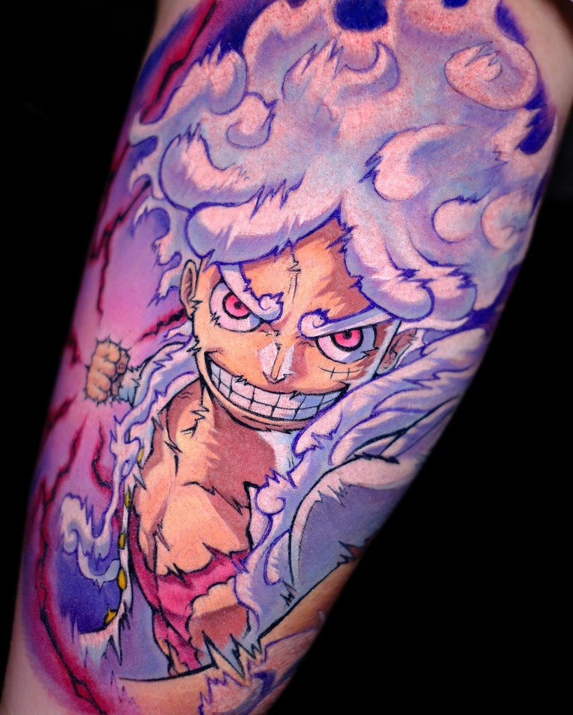 An action-packed tattoo featuring Gear 5 Luffy mid-punch, with dynamic motion lines emphasizing his attack. The bold color palette of pinks, blues, and whites adds intensity to his expression and fluid movement, perfectly encapsulating his larger-than-life personality.