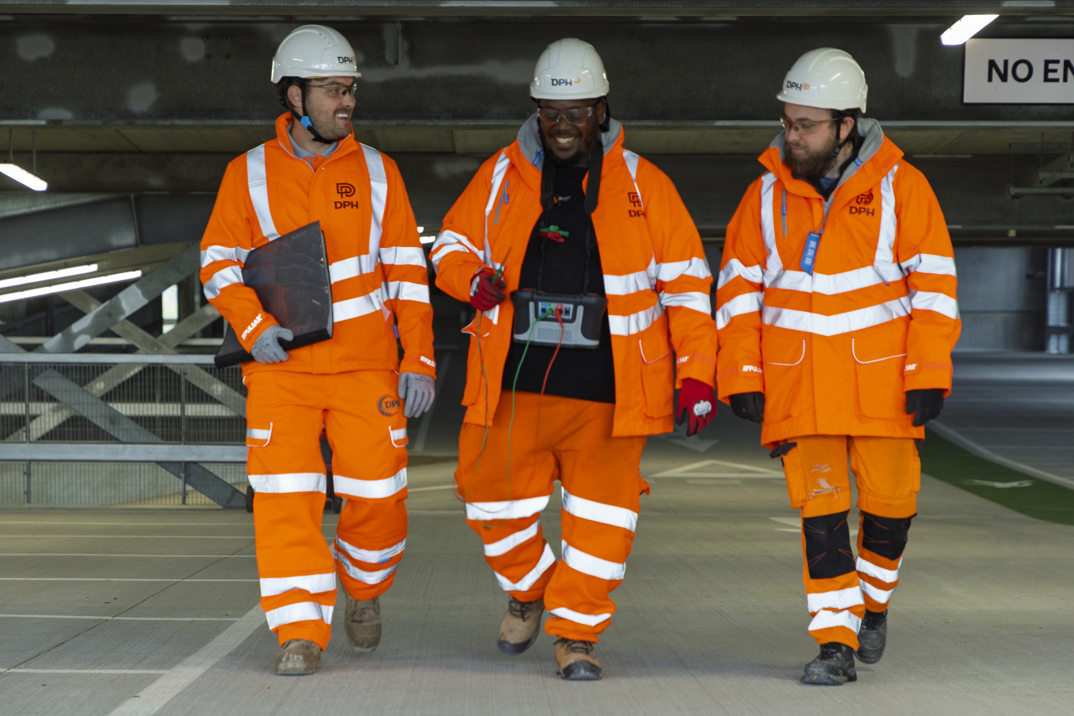 Modern glass buildings with illuminated facades and trees on a rainy day