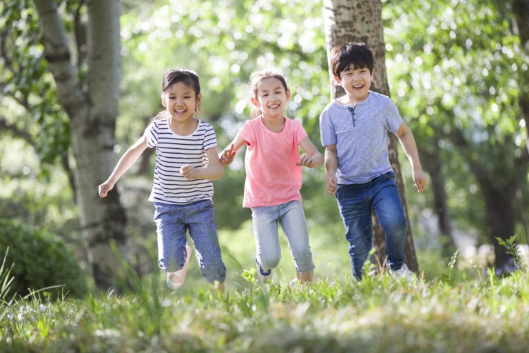 Children playing outdoors, wearing EMF protective wristbands