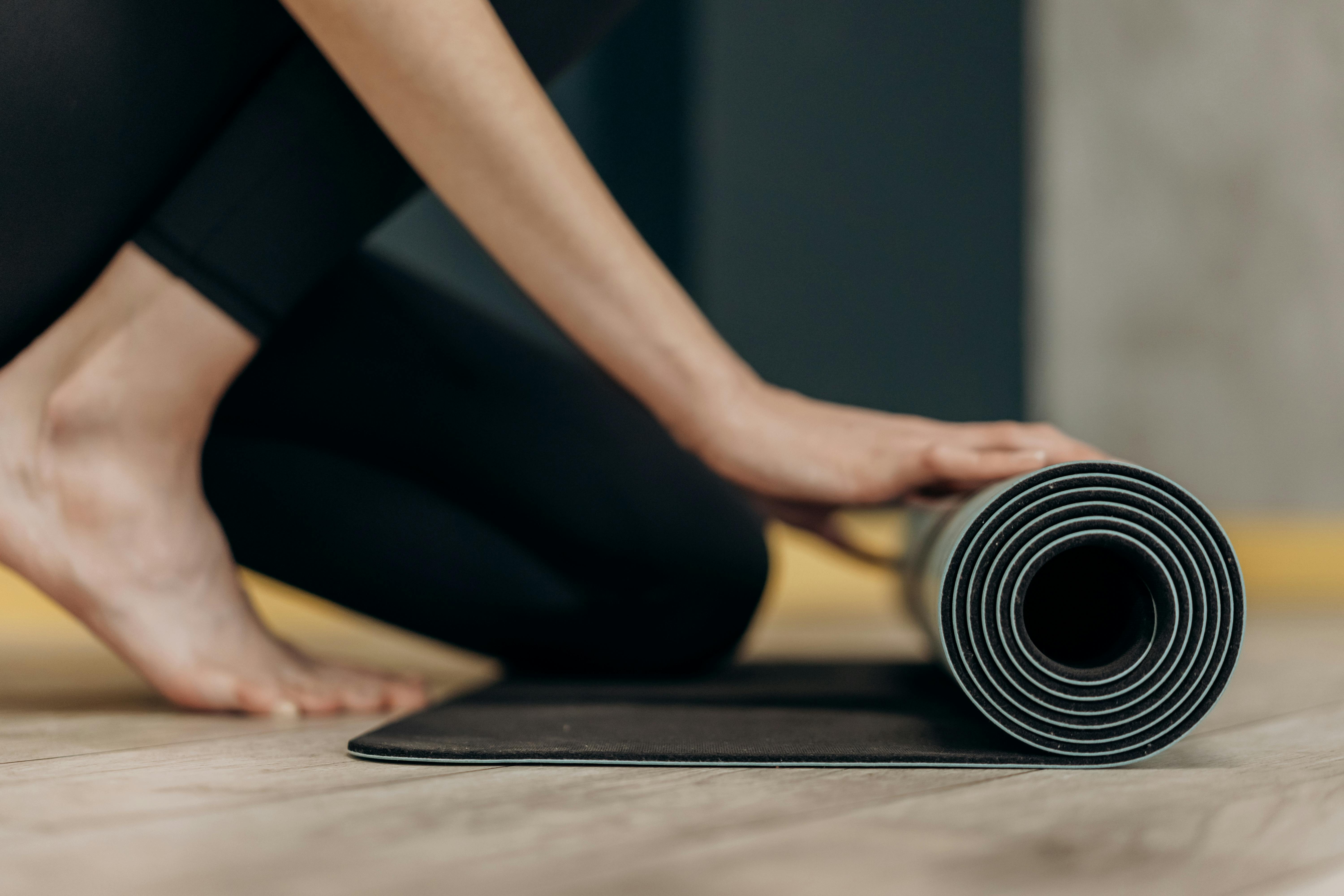 person unrolling yoga mat