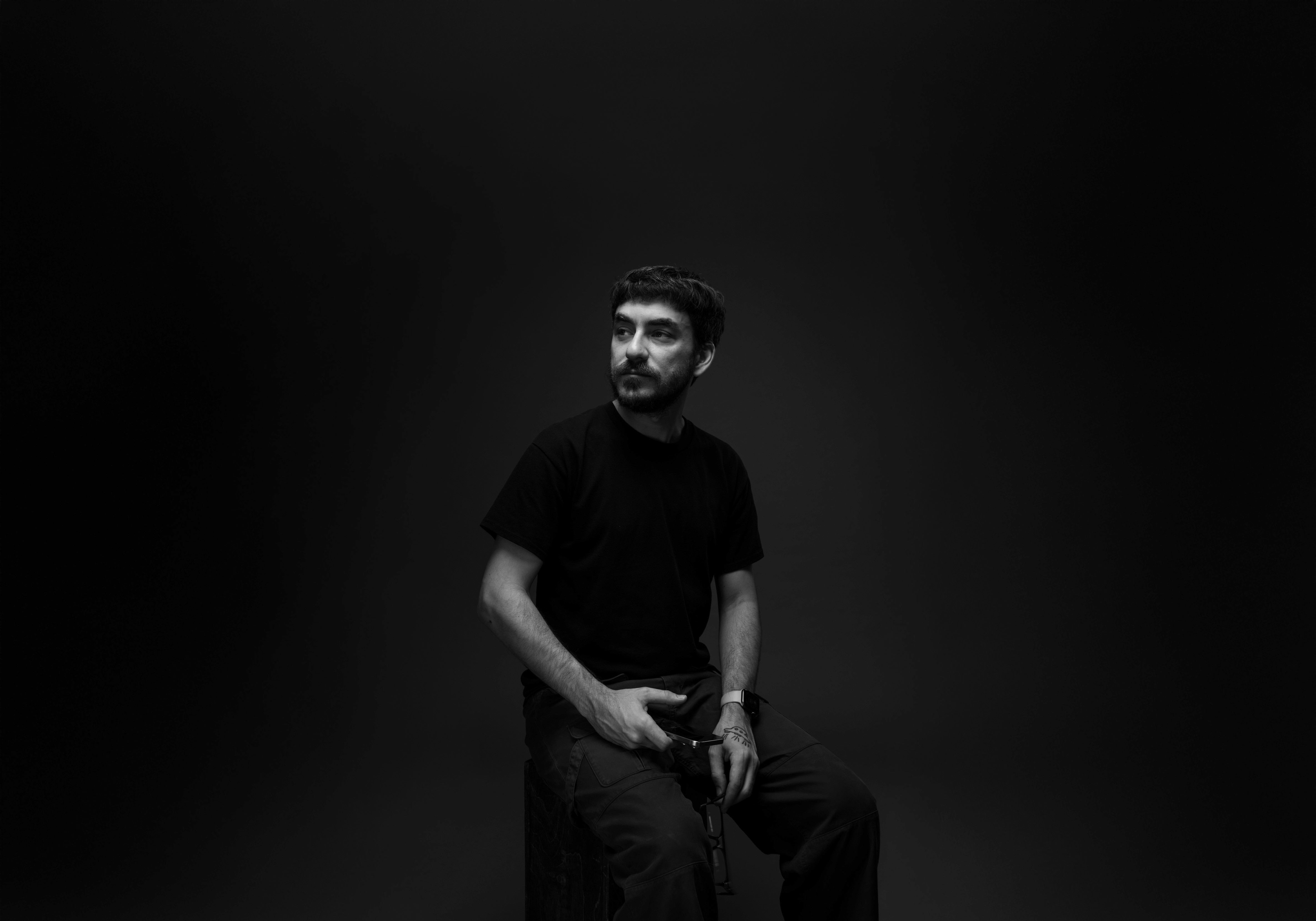 Black-and-white portrait of Nick TK Pinto seated and looking off camera.