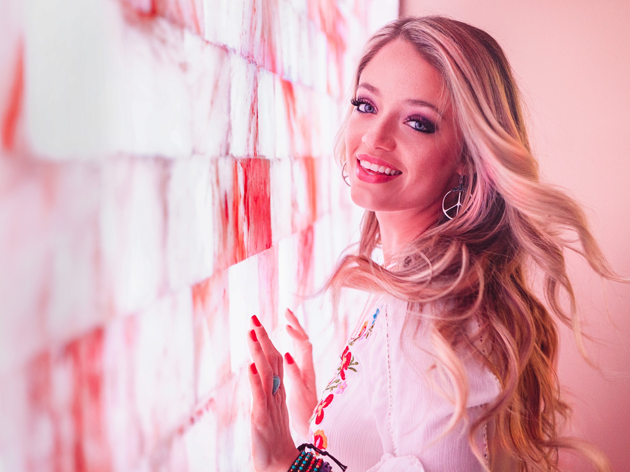 Editorial portrait of country artist  Jordyn Mallory against a pink Himalayan salt wall, showcasing expressive portrait photography with soft light and modern editorial styling.