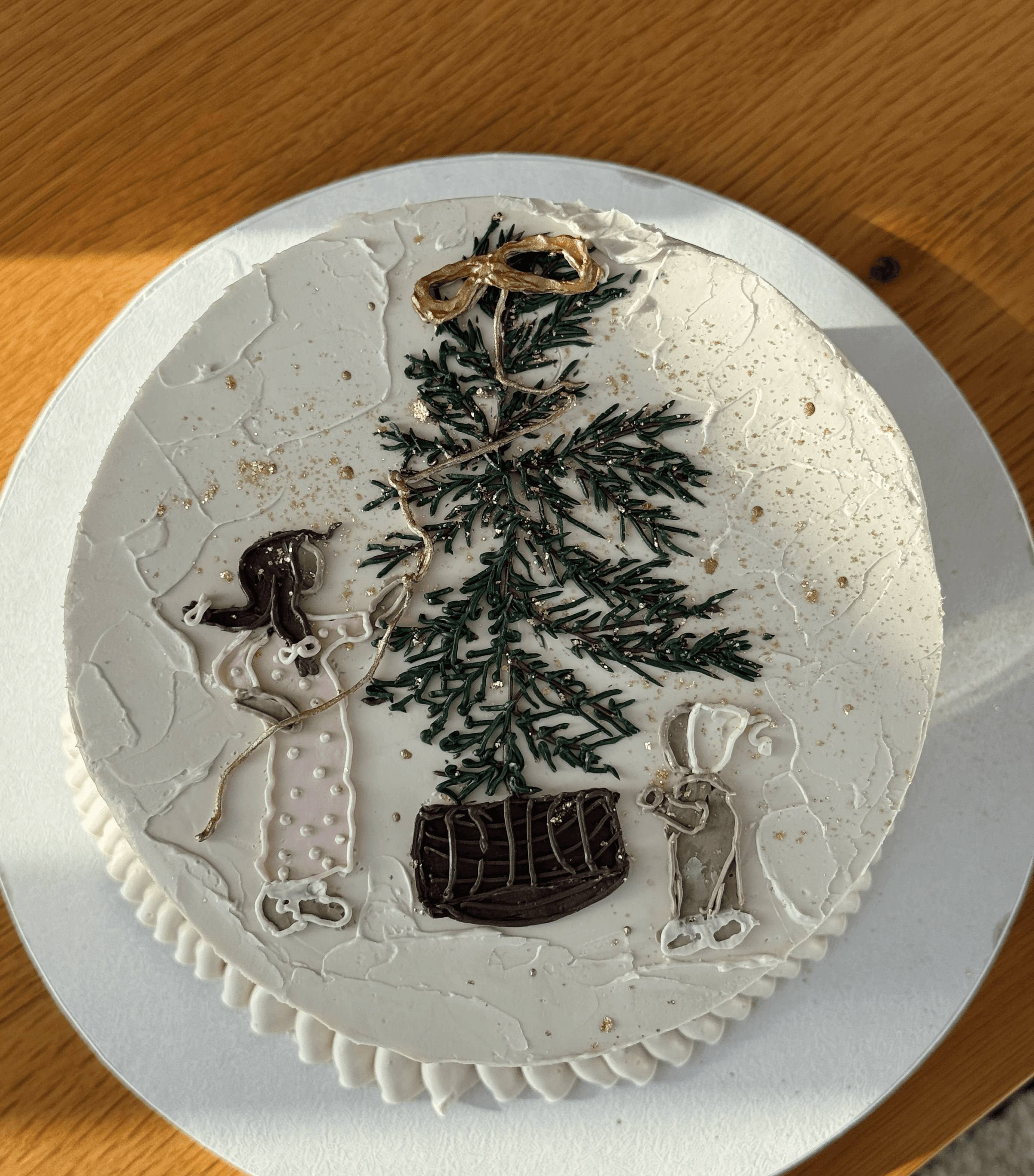 White buttercream cake decorated with pink petals and delicate green stems