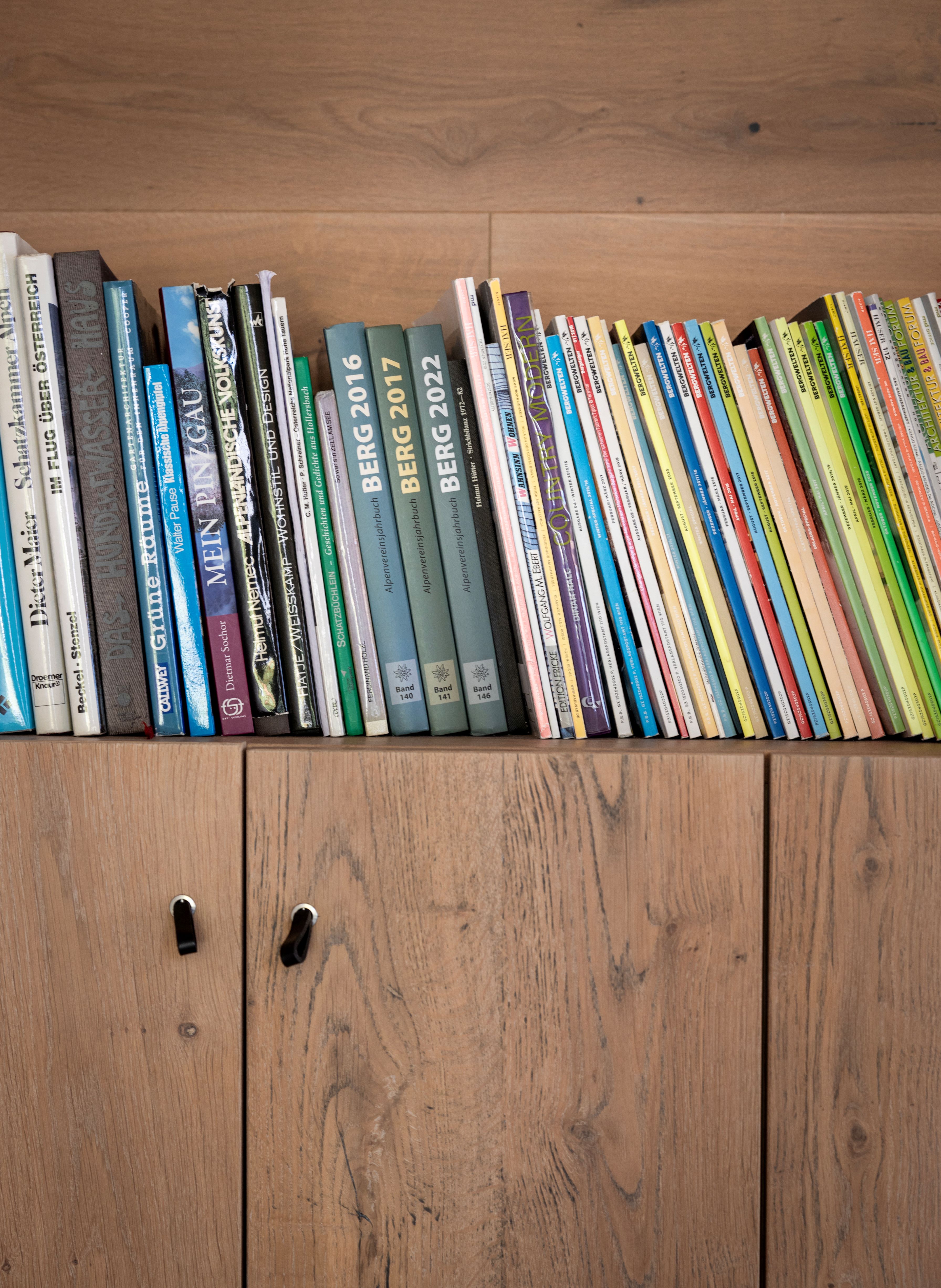 Colourful books on a wooden cabinet