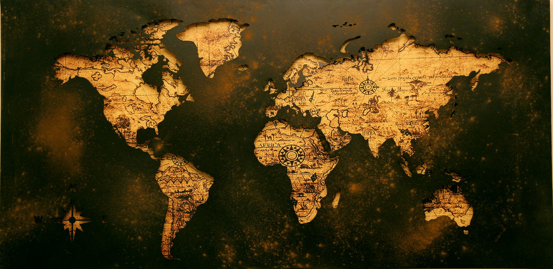 Close-up of a students hands examining a weathered historical letter and a vintage compass on a wooden desk.