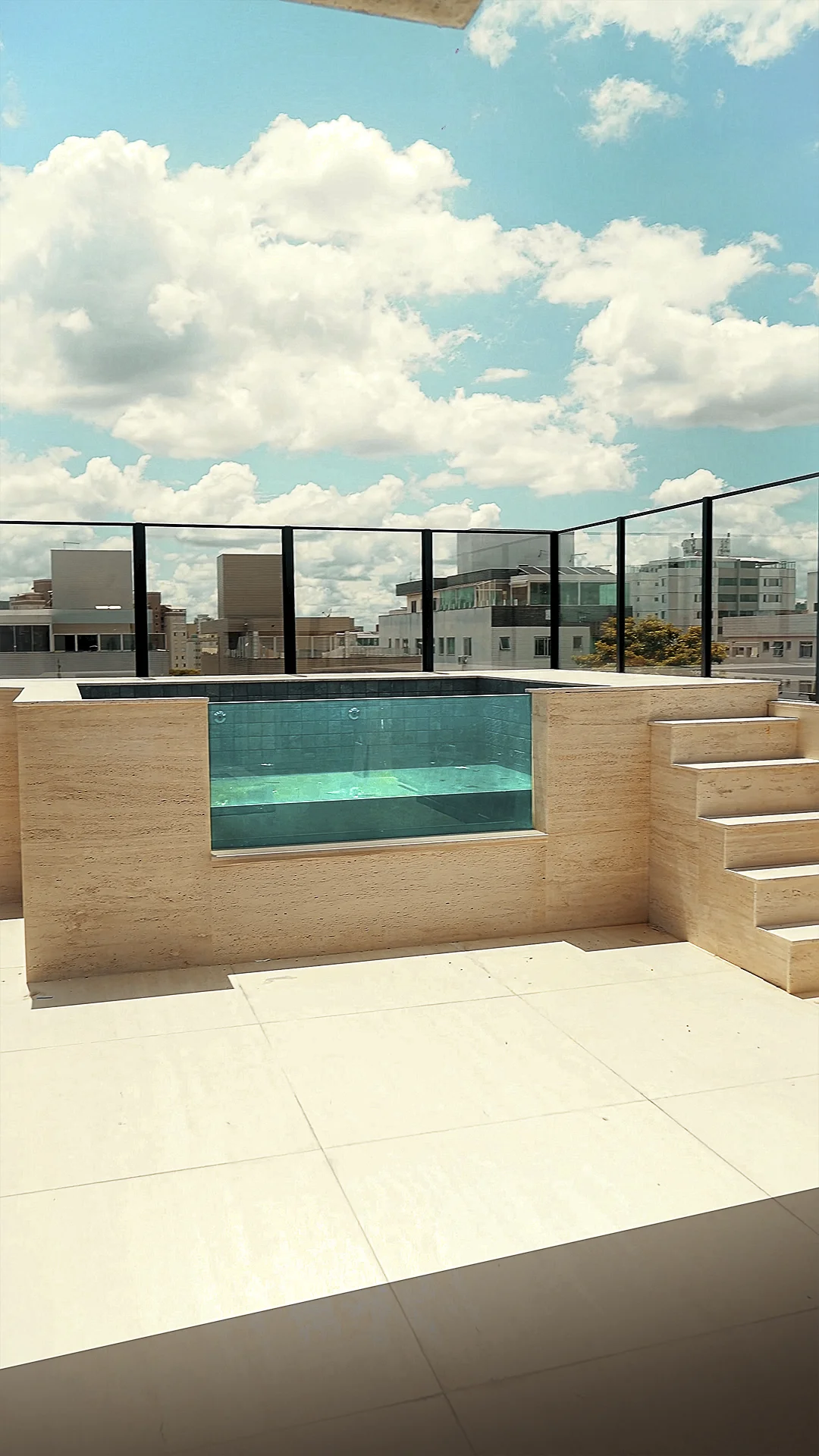 Piscina de borda de vidro instalada em rooftop, com acabamento em pastilhas