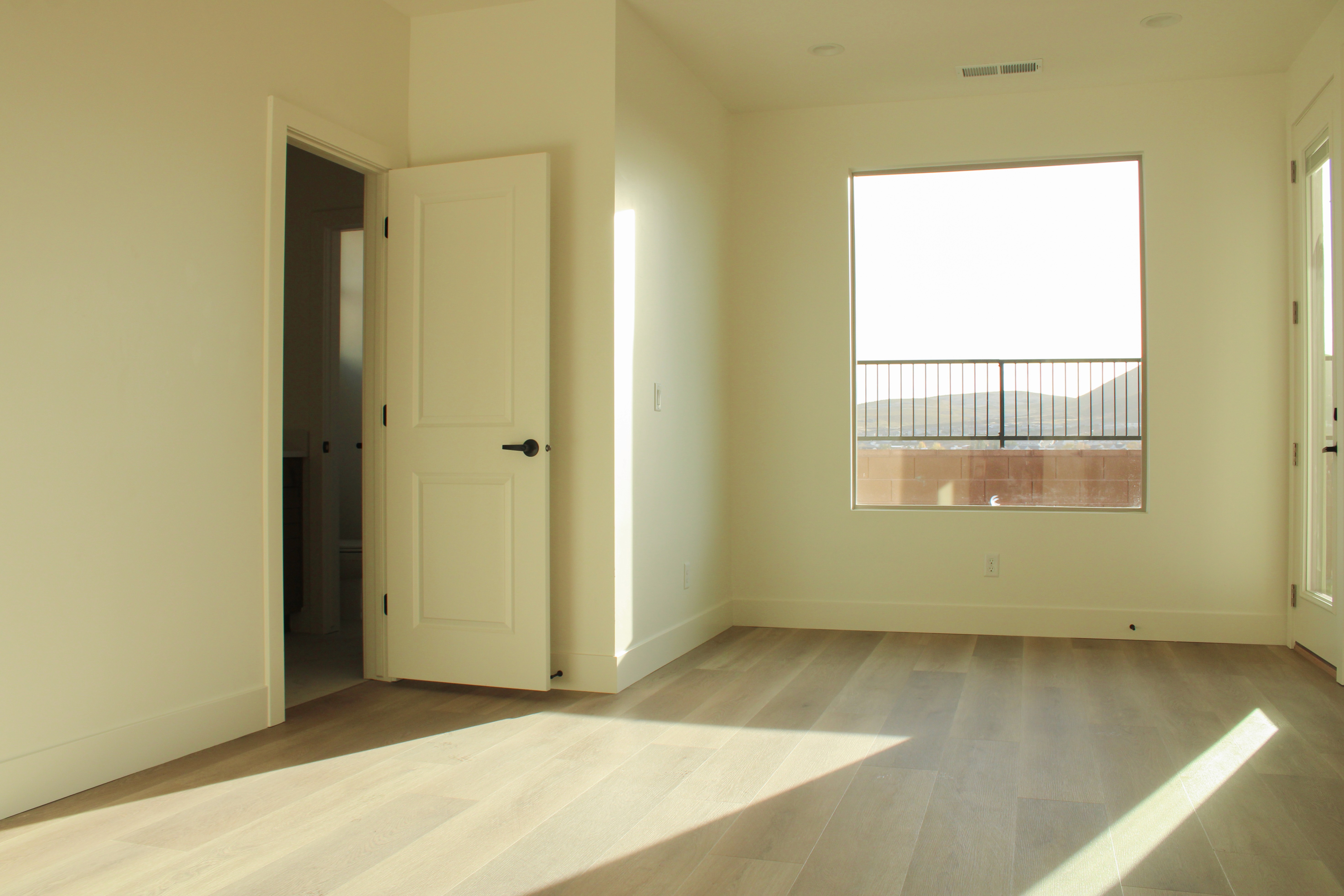 Primary bedroom inside the Golden Hour home in Hurricane, Utah with bright windows and spacious layout.