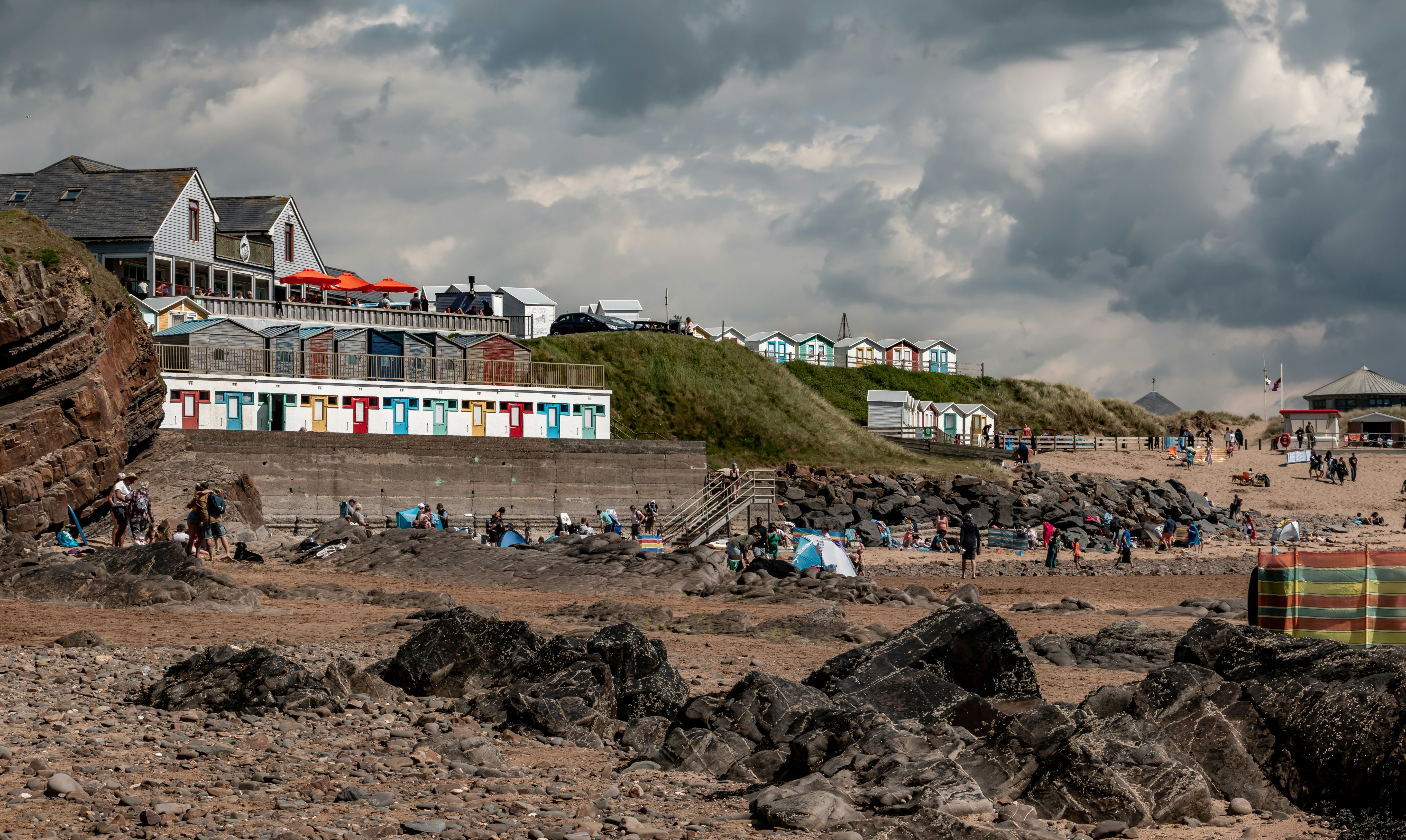 a group of people standing on top of a sandy beach