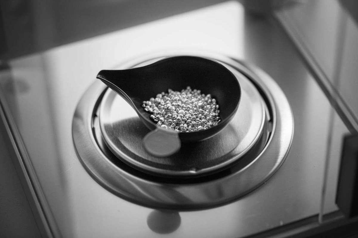 Platinum and palladium scrap being weighed on a precision digital scale for refining valuation.