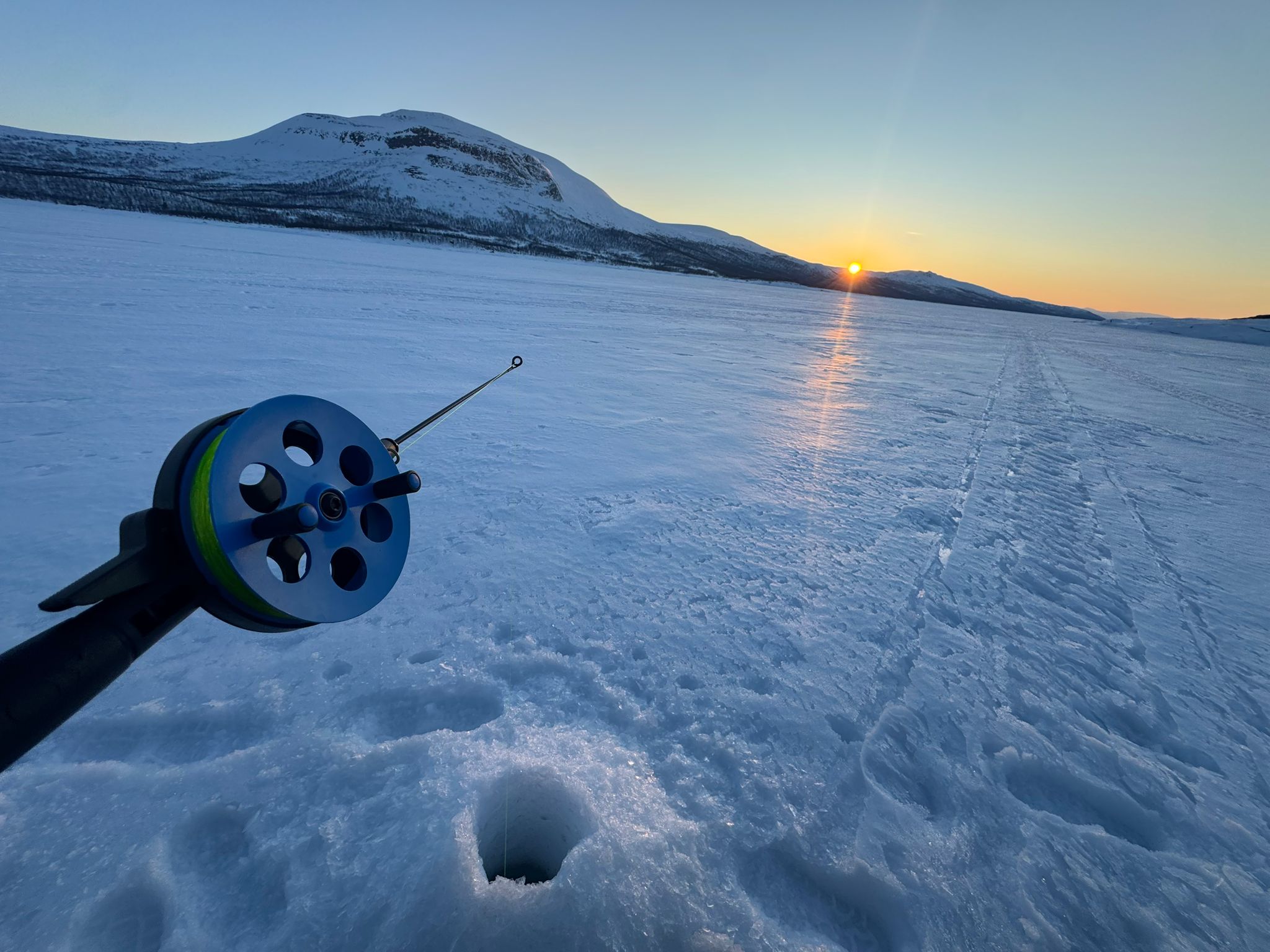 a snow covered street with houses and trees