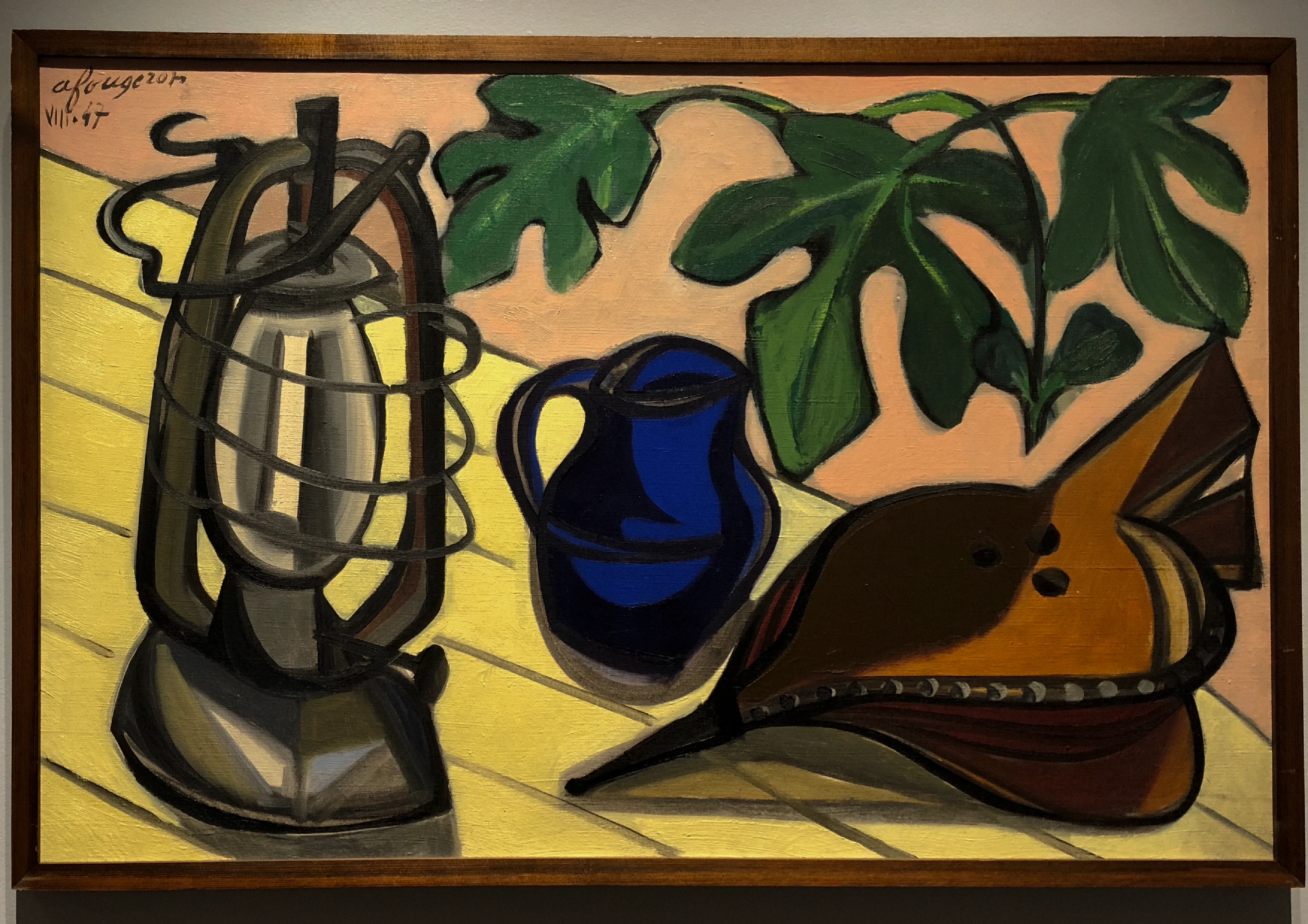 Painting of a still life on a table: an oil lantern, a deep blue jug, a fish, and large dark fig leaves behind, in flat bold colour.