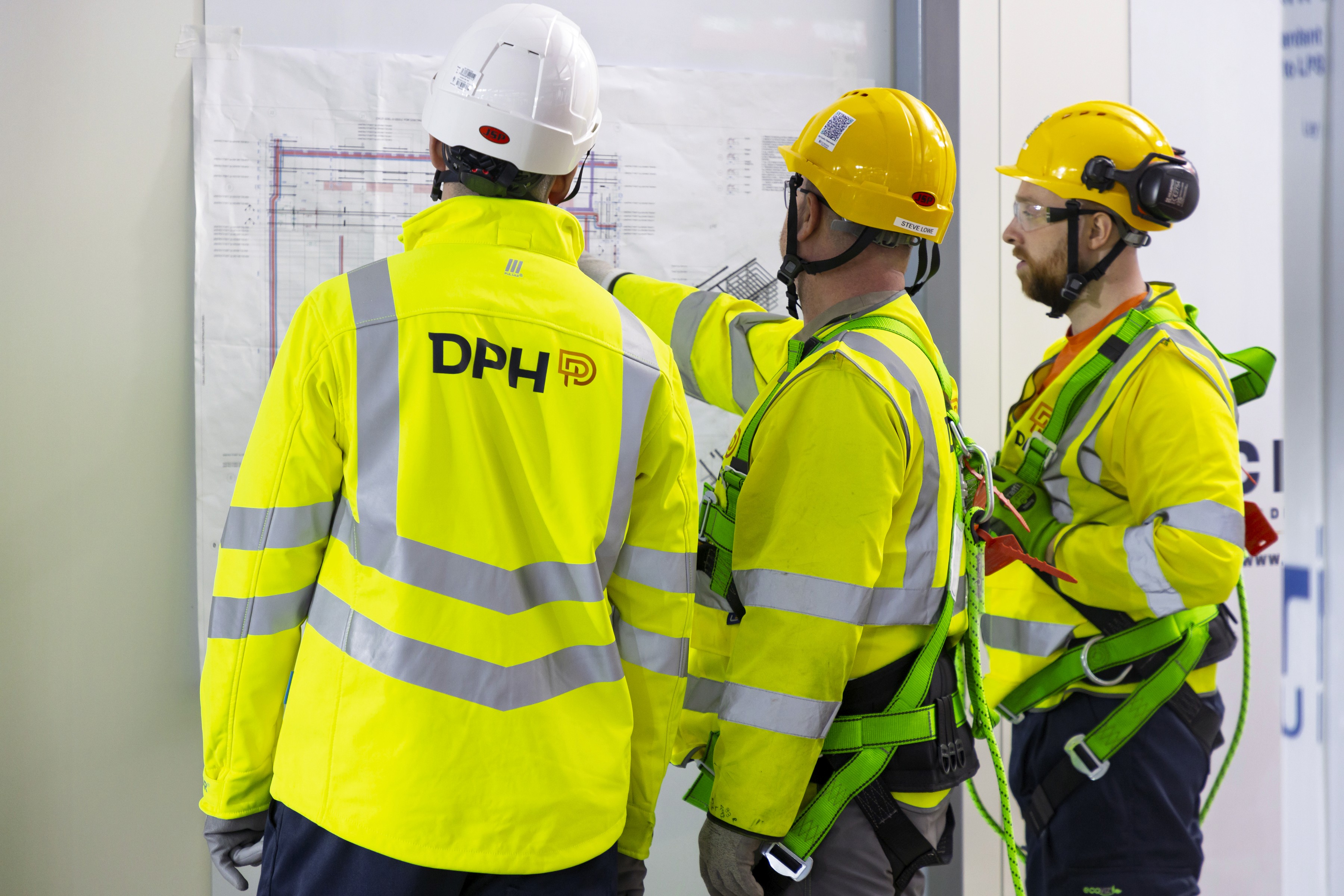 Modern glass building with illuminated facade and cityscape view at sunset