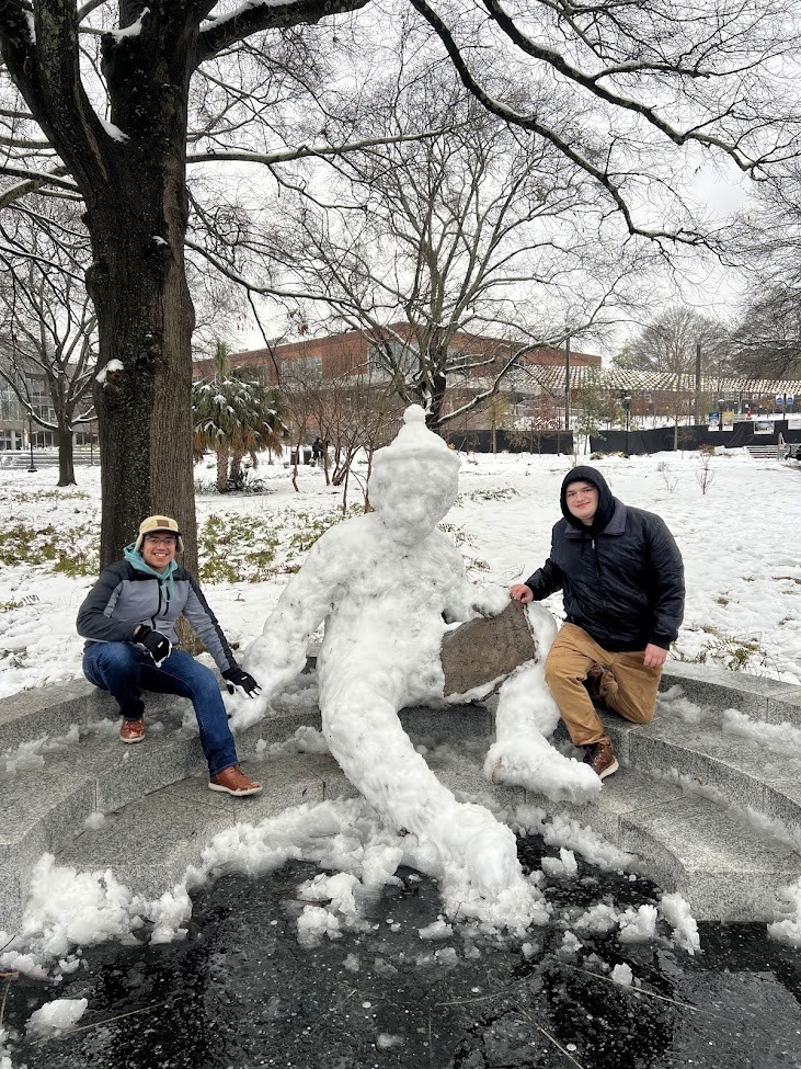 Family wearing traditional attire with lanterns, father holding a daughter up.