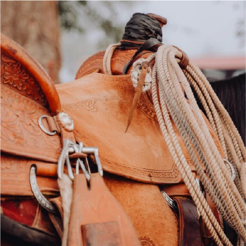 A person rides a horse while another watches.