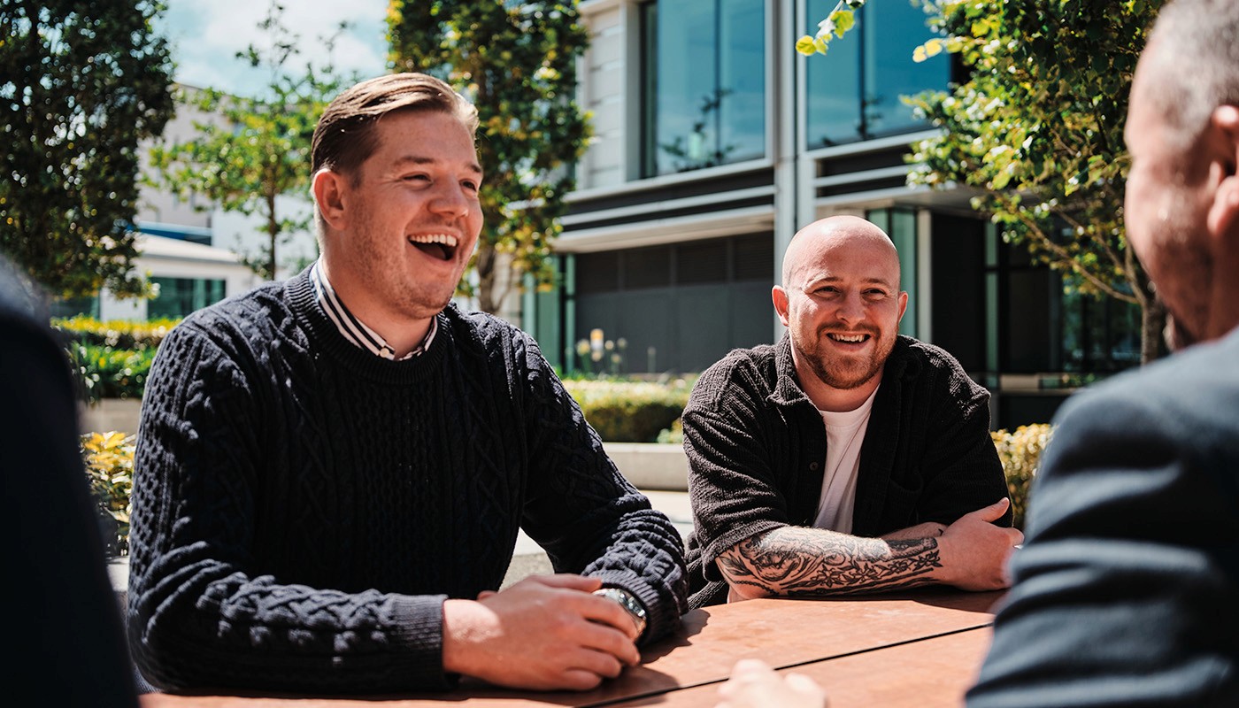 YOONO employees laughing over a meeting