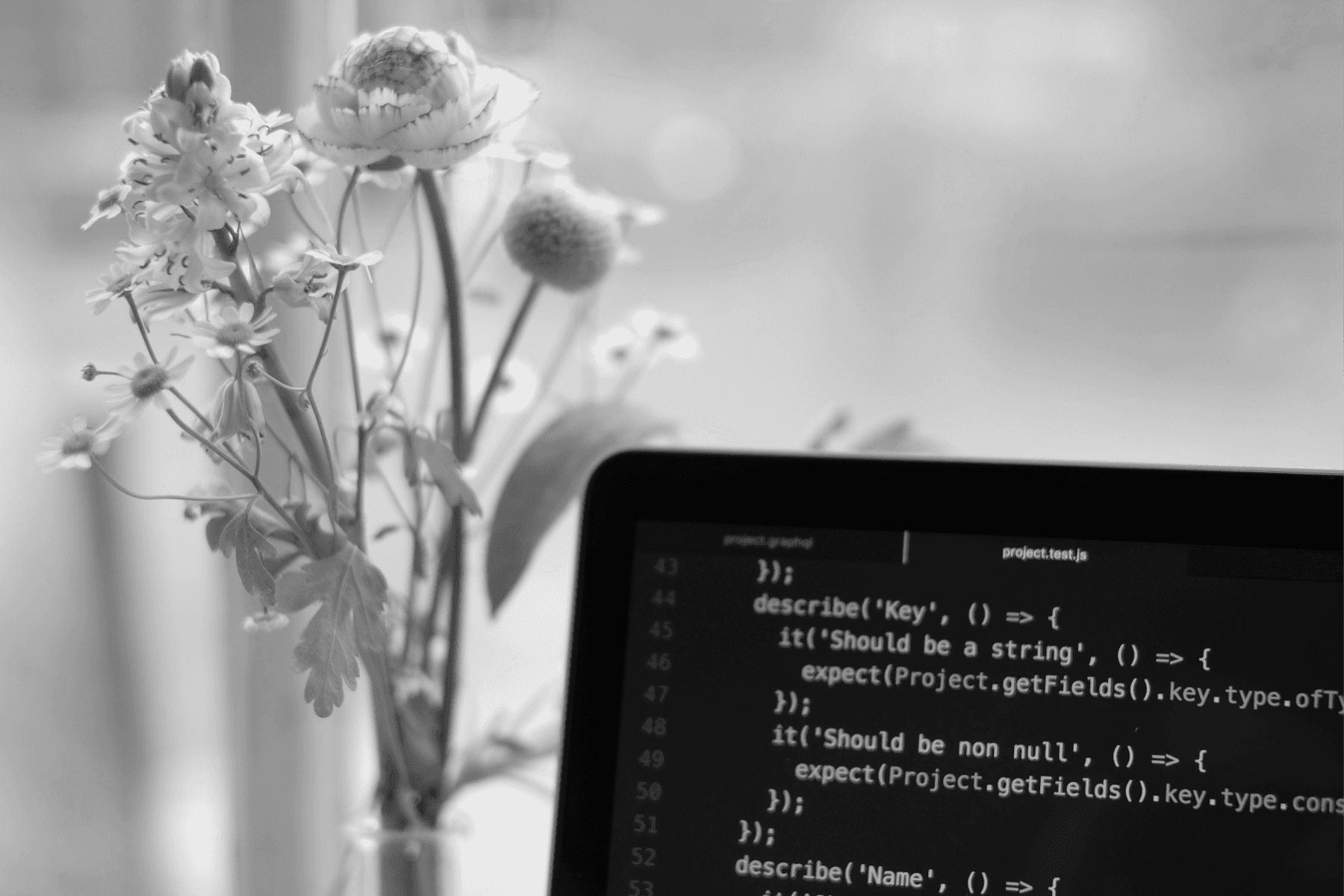 A close-up corner of an IDE next to a vase of flowers.