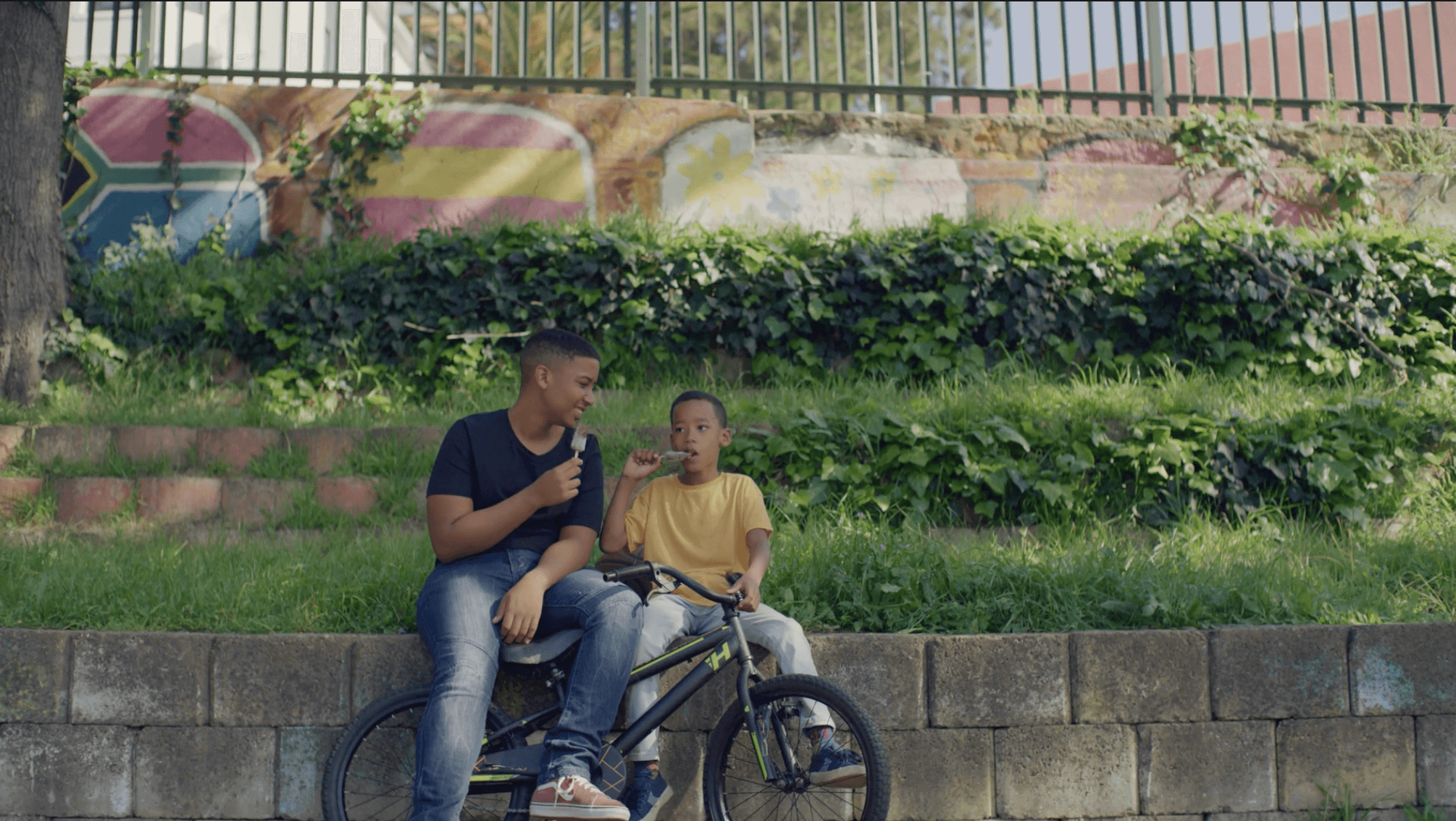 Black futuristic car in front of a modern building with glass front