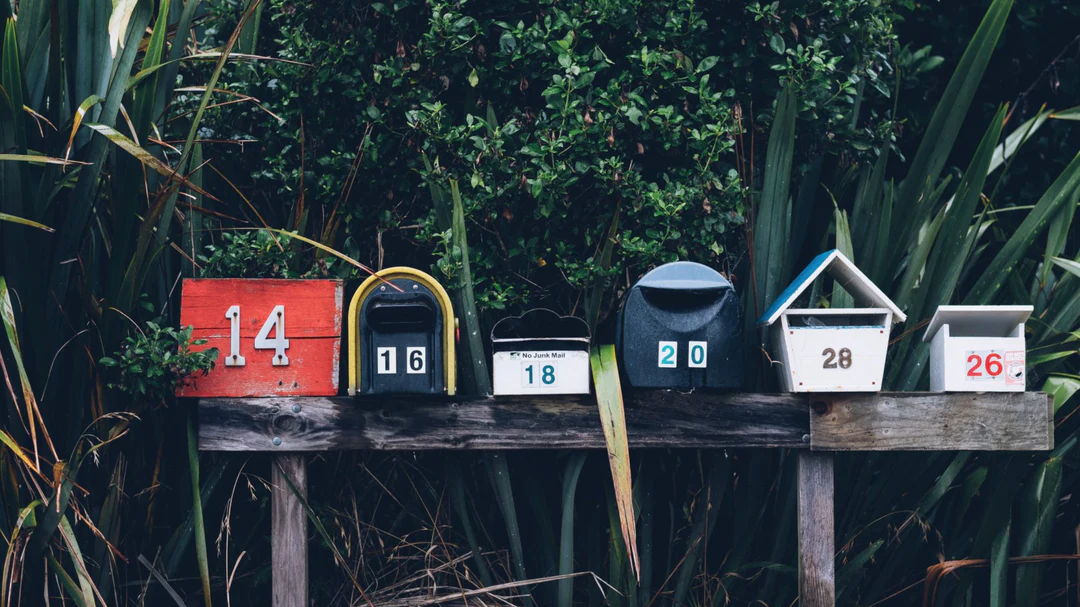 numbered mailboxes on a wooden bench