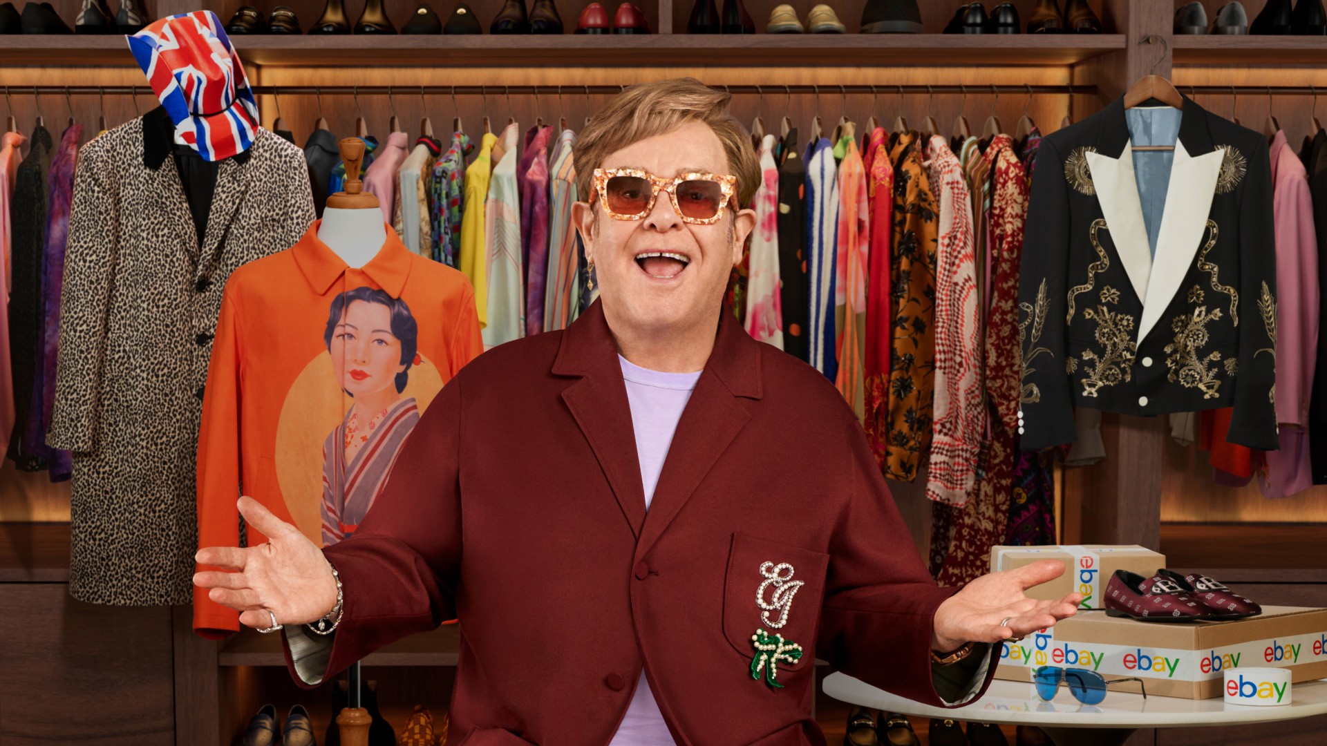 Elton John standing in a wardrobe room for the eBay charity sale campaign