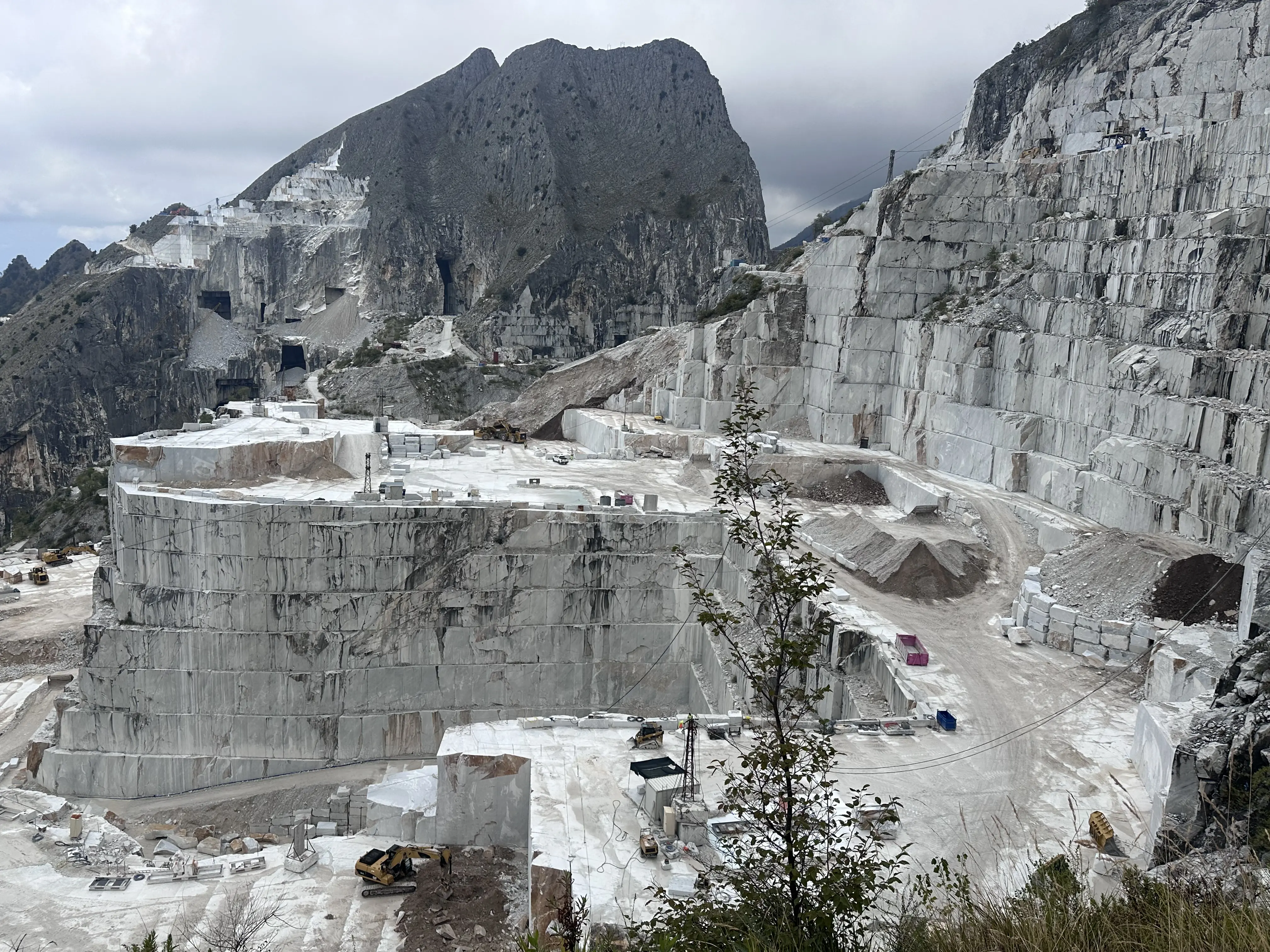 Carrara-Steinbruch mit gestuften Abbaustellen und Marmorblöcken