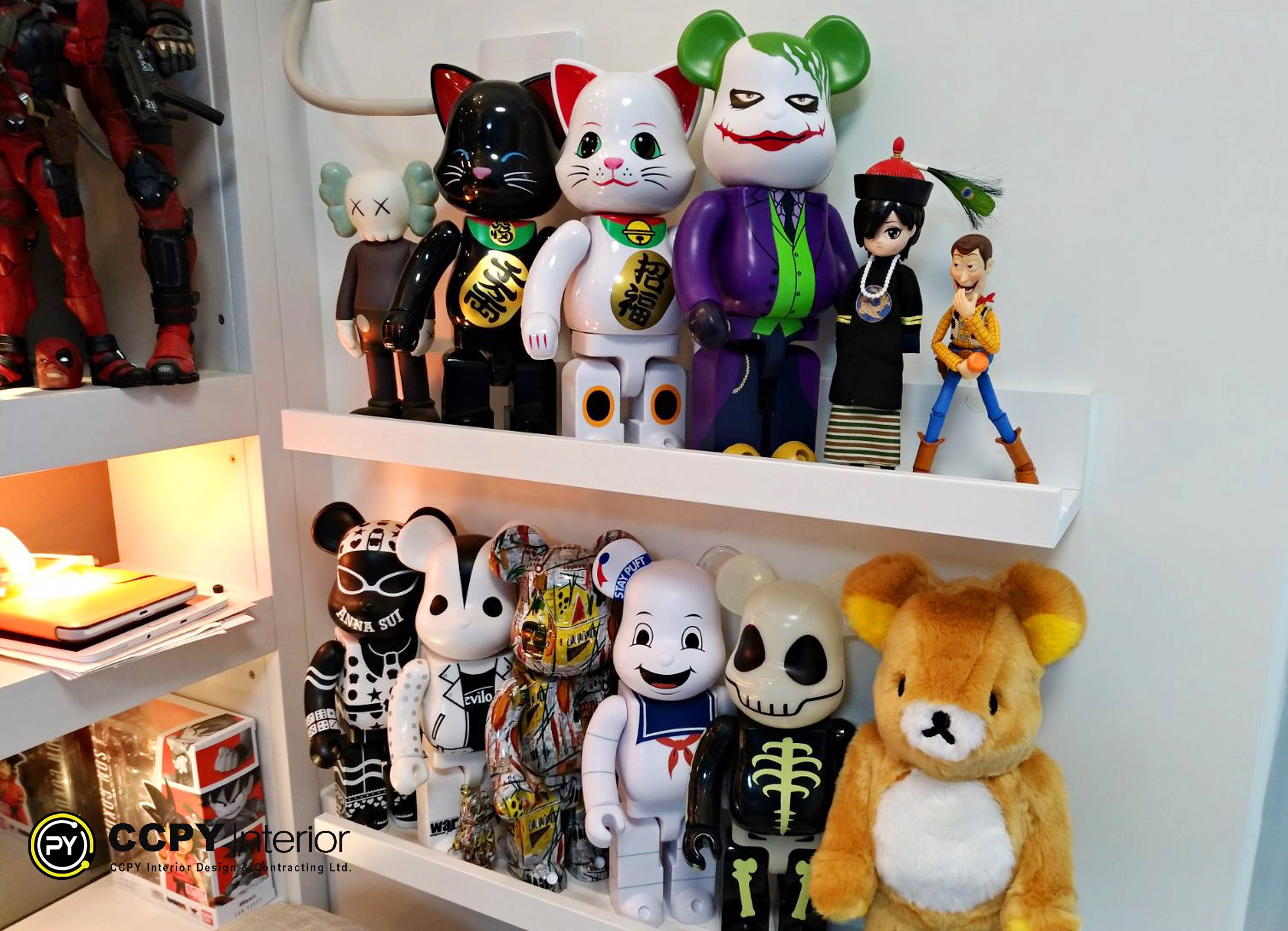 The selected region showcases a collection of designer toys and pop-culture figurines arranged on wall-mounted floating shelves.Featured FiguresKaws: Distinctive "Companion" figures with "X" eyes are visible on the top shelf.Chucky: The notorious horror movie doll is positioned on the far left of the top shelf.Maneki-Neko (Lucky Cat): Two large, stylized white lucky cat figures sit prominently in the center.Jack Skellington: The main character from The Nightmare before Christmas stands on the bottom shelf.Stay Puft Marshmallow Man: The iconic giant monster from Ghostbusters is located on the bottom shelf.Rilakkuma: The popular Japanese bear character sits on the far right of the bottom shelf.Woody: A small figurine of the cowboy character from Toy Story rests near the right edge.