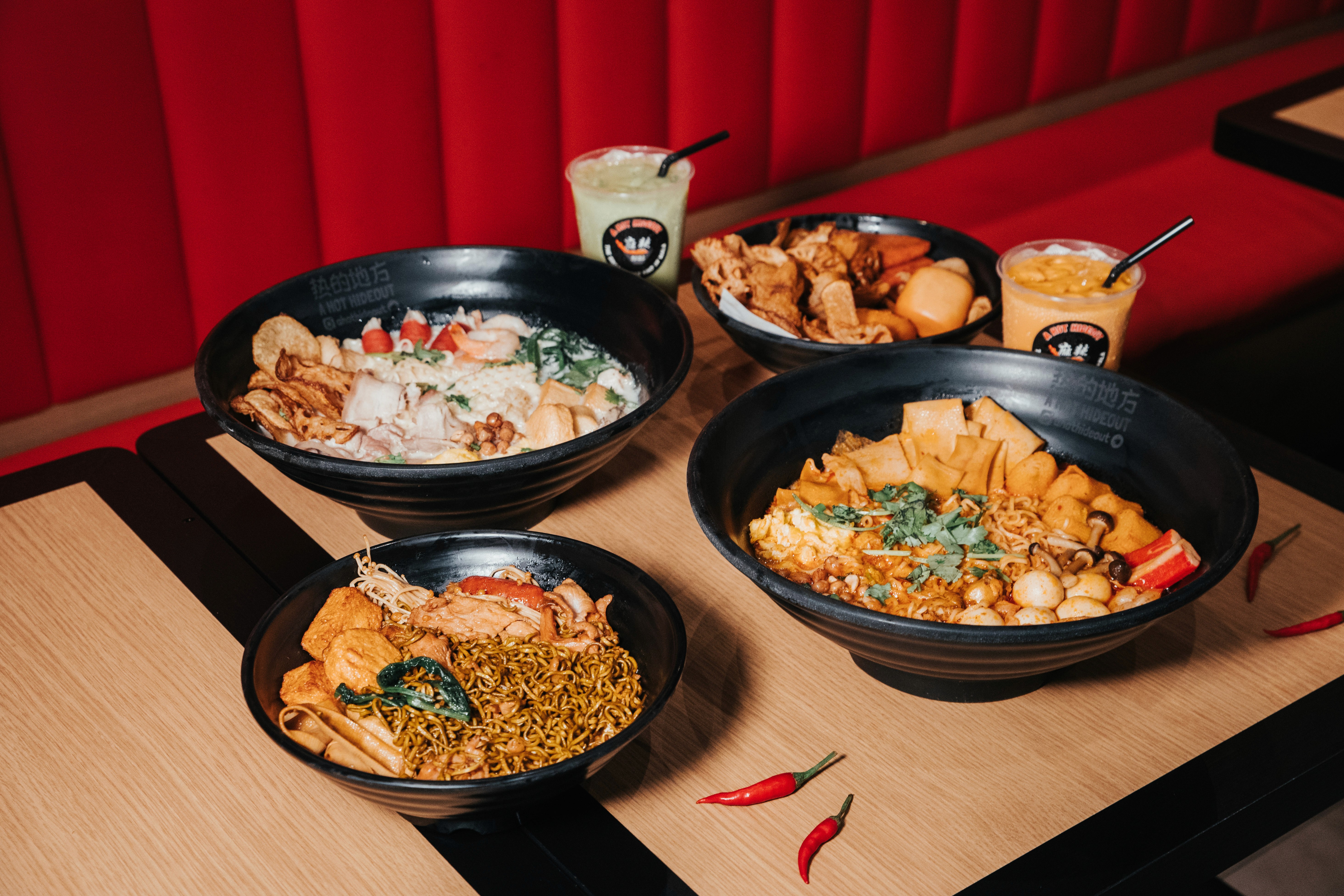 Commercial food photography of a customisable hotpot spread in a modern Singapore restaurant.