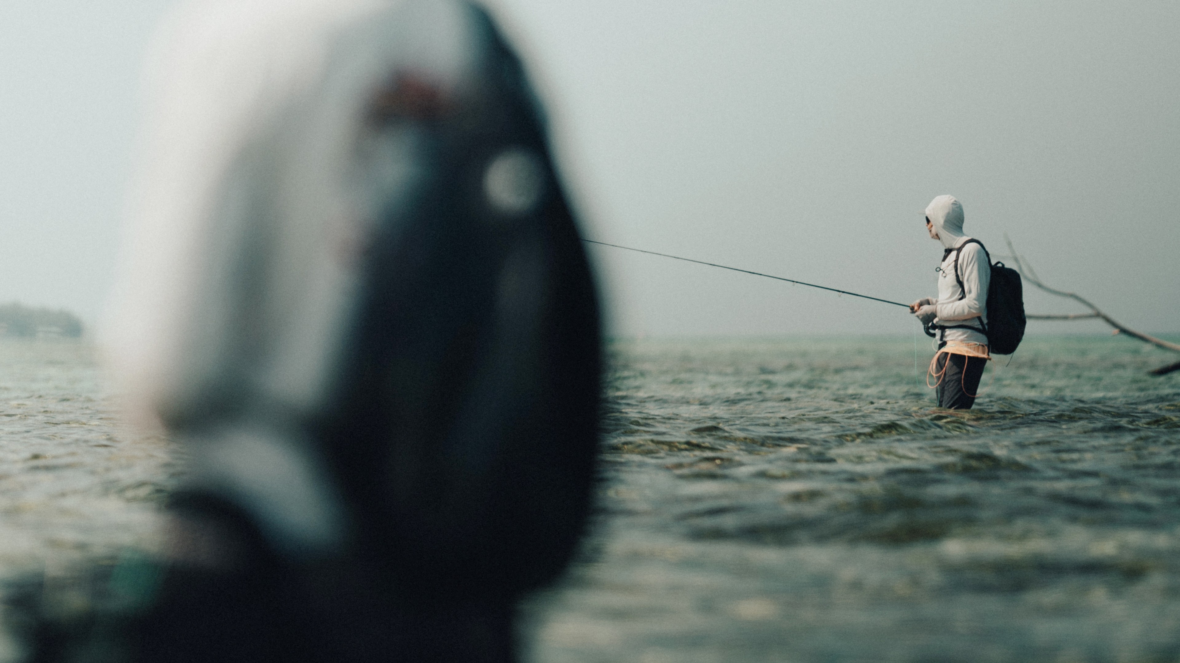 Two anglers vading shallow flats flats looking for permit and bonefish