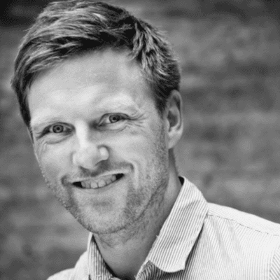 Headshot of employee, Stig Salling, on a blue tinted, grey background