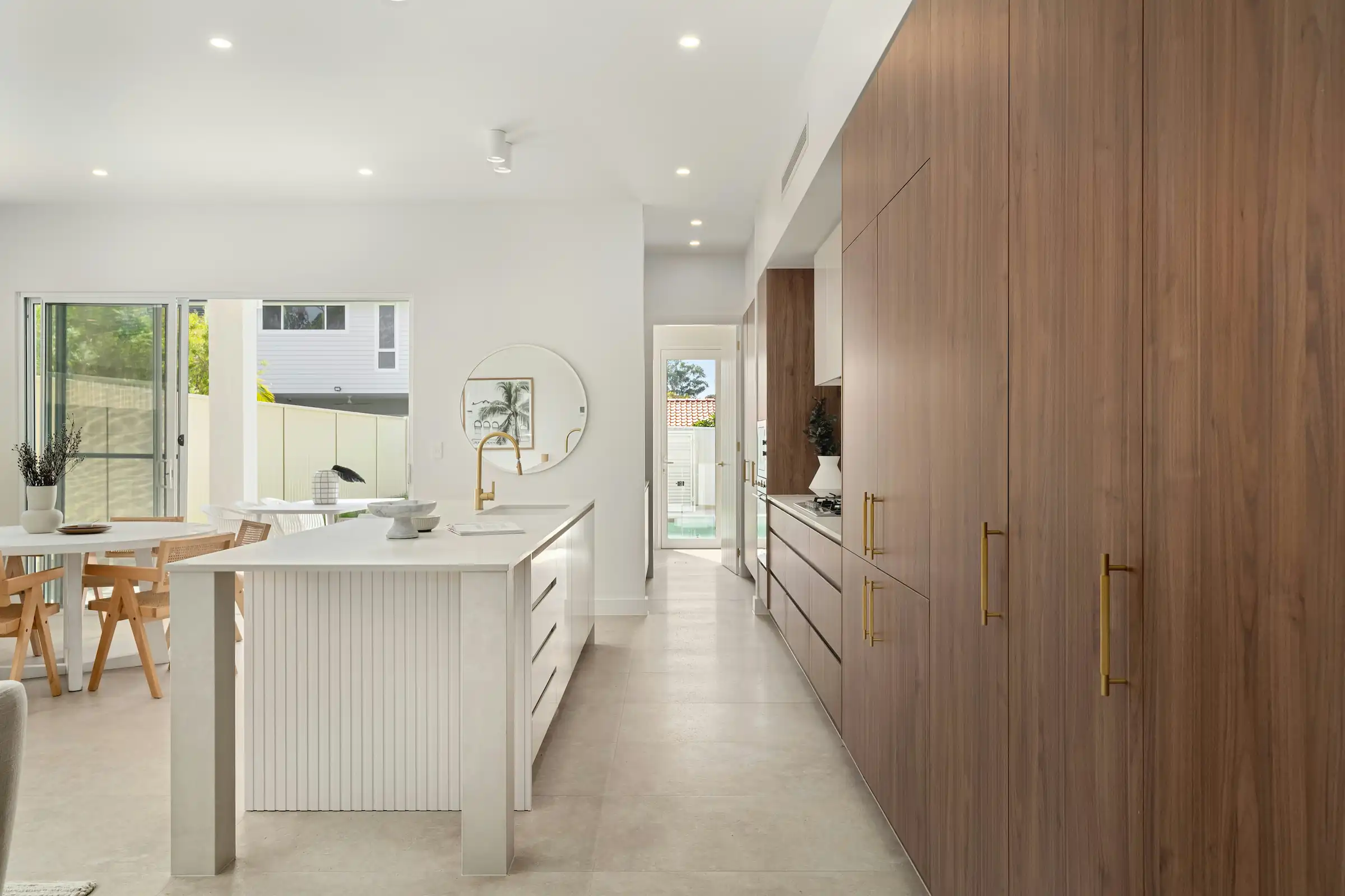 Minimalist living space featuring oak flooring, timber wall panels and panoramic windows with natural light.