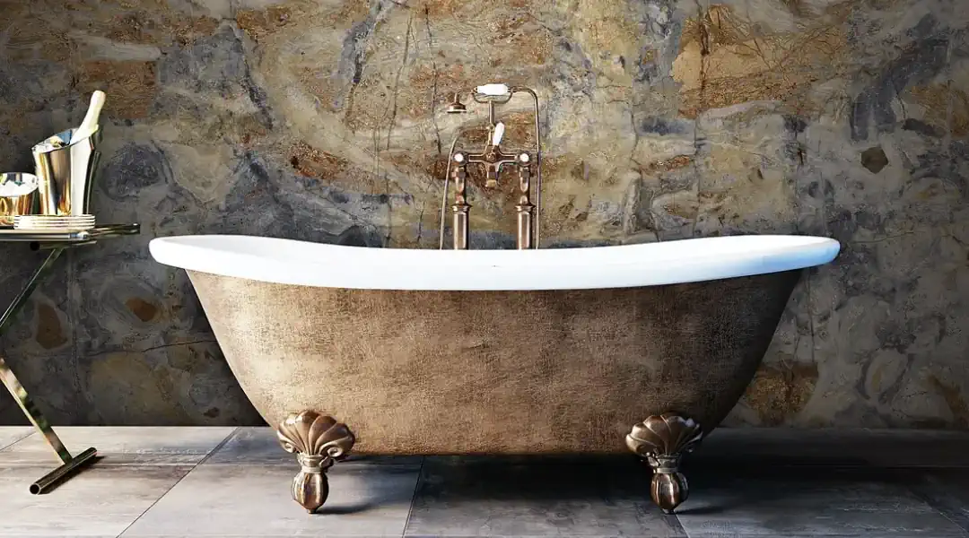 Luxurious gold-finished bathtub against elegant marble wall at Skinrock