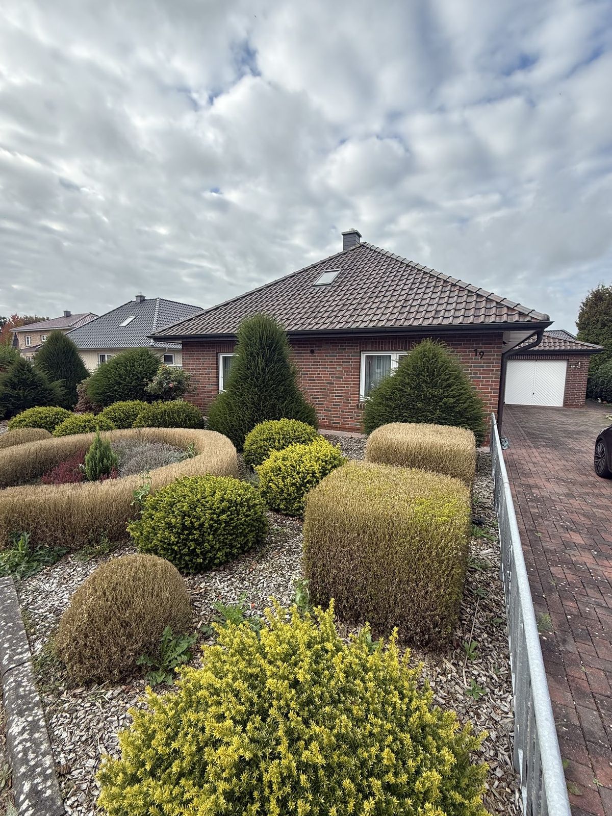 Hauszugang mit Gartentor und geschnittener Hecke